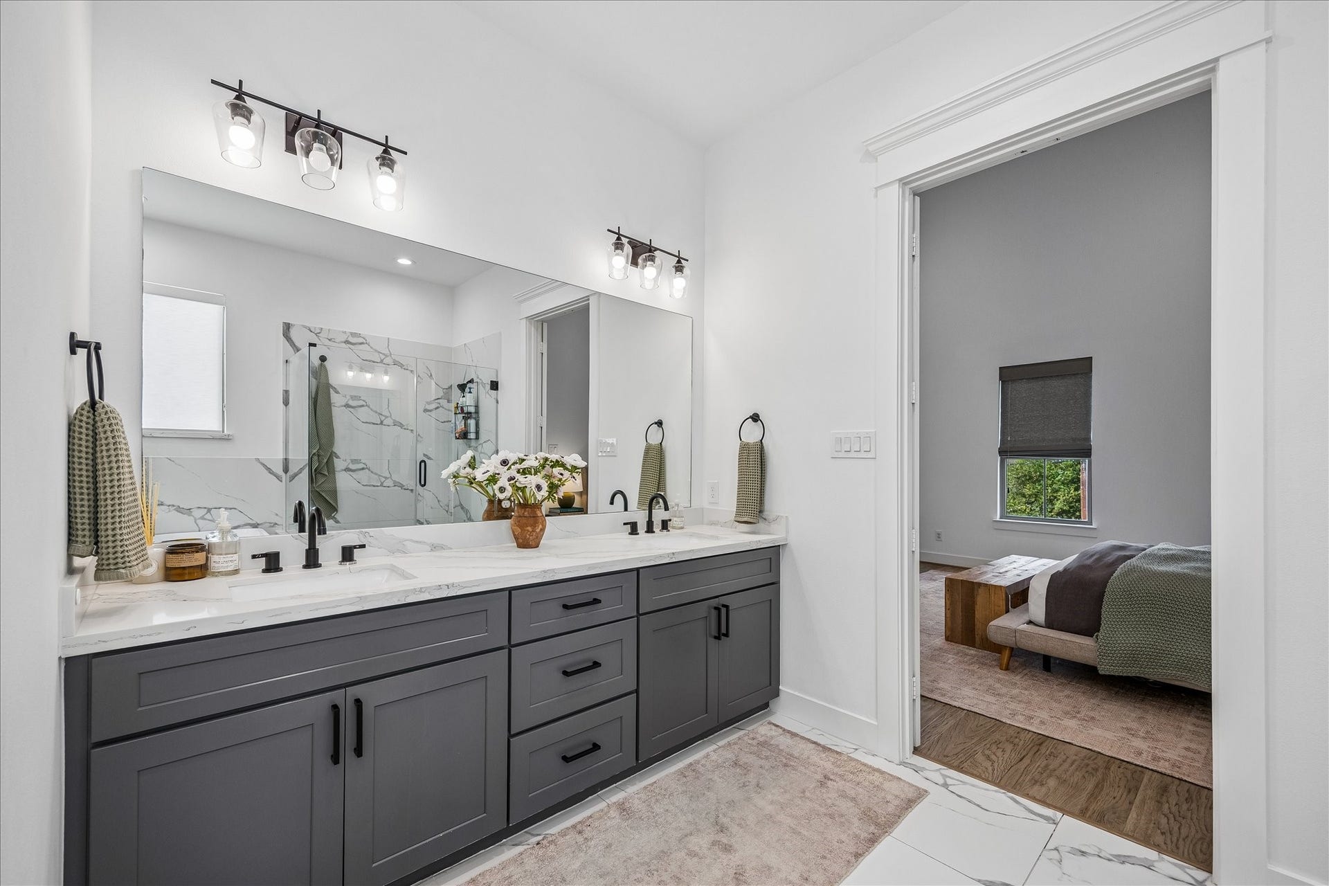 2320 Couch Street, Houston, TX 77008 Your daily routine gets a stylish upgrade here. A long quartz topped dual sink vanity offers plenty of counter space and storage, while the wide mirror and chic vanity lighting keep the space bright, polished and ready for busy mornings or slower evenings.