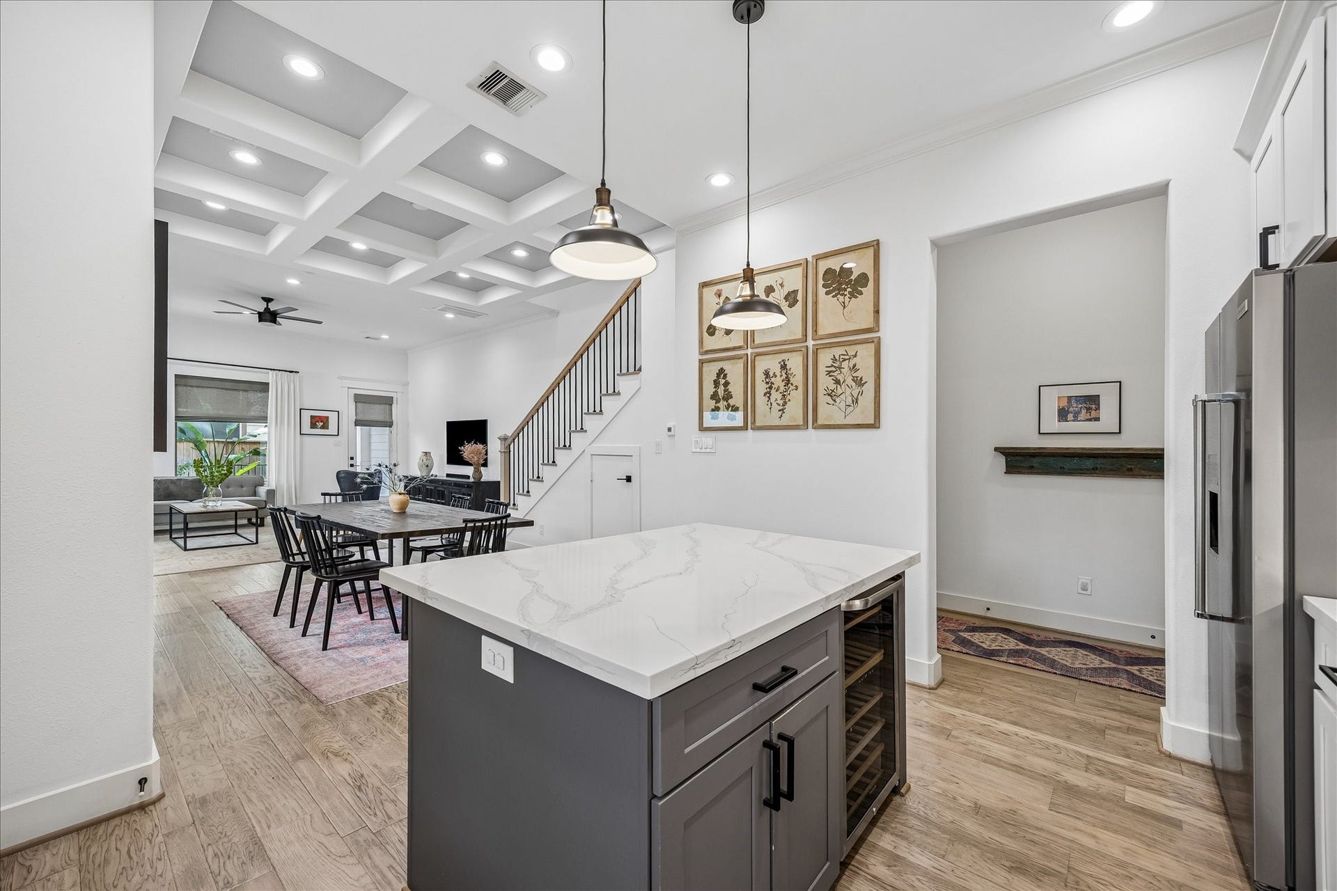 2320 Couch Street, Houston, TX 77008 Morning coffee, late night snacks and all the little stops in between happen right here. The contrasting island offers handy bar seating and a built-in beverage chiller, while the doorway to the right leads to the powder bath and garage entry for easy everyday comings and goings.