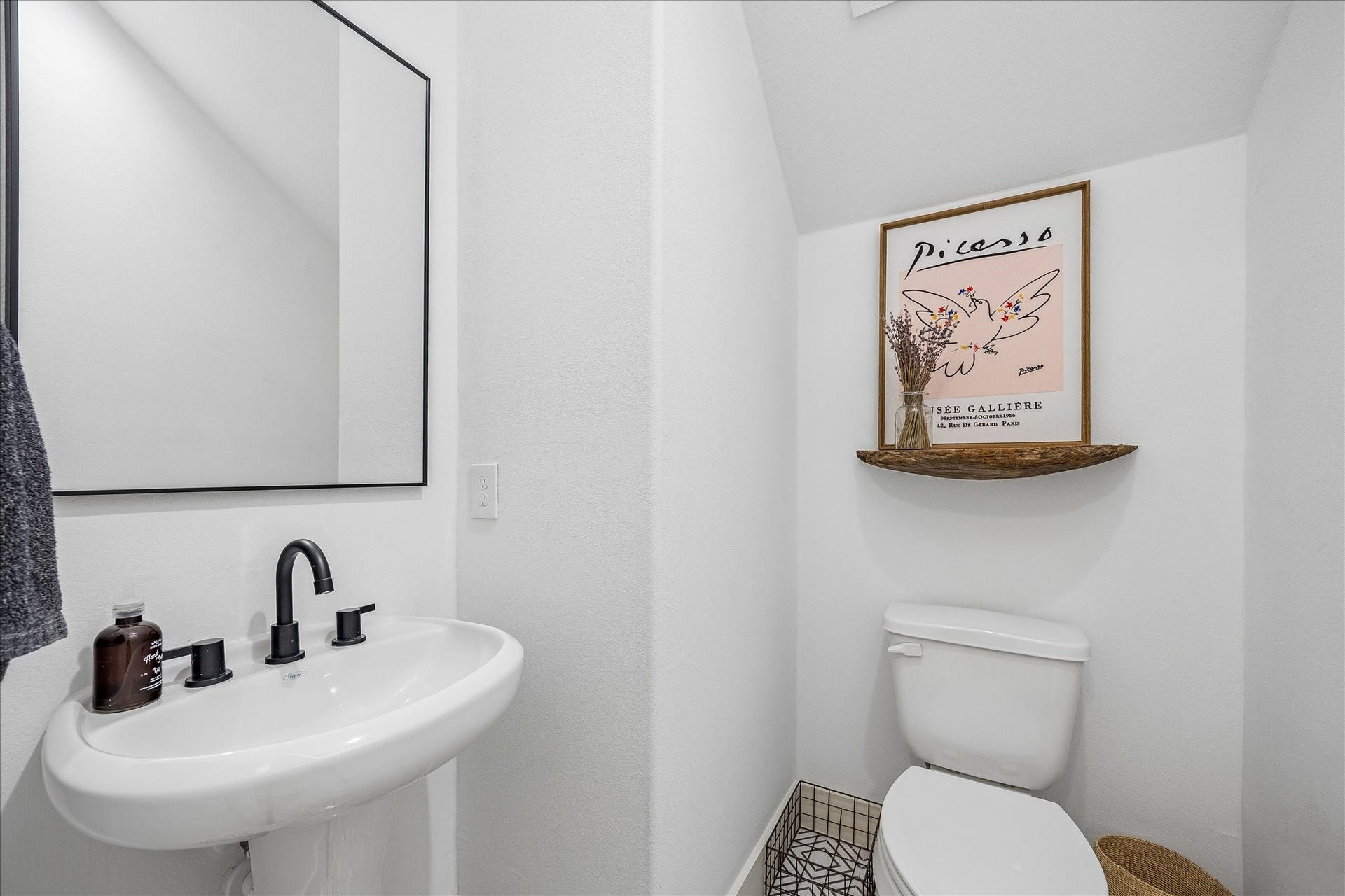 2320 Couch Street, Houston, TX 77008 The first-floor powder bathroom is perfect for guests and daily use with a classic pedestal sink with modern fixtures, a stylish mirror, and designer tile flooring.