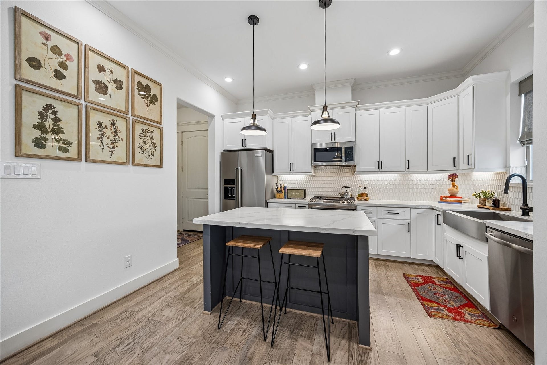 2320 Couch Street, Houston, TX 77008 Show off your culinary skills in a kitchen that is fully loaded and ready to entertain. Sleek stainless steel appliances include a gas range, microwave, dishwasher and in island beverage chiller, while quartz counters, stylish tile backsplash, crisp white cabinetry and a contrasting island give the whole space a polished designer finish.