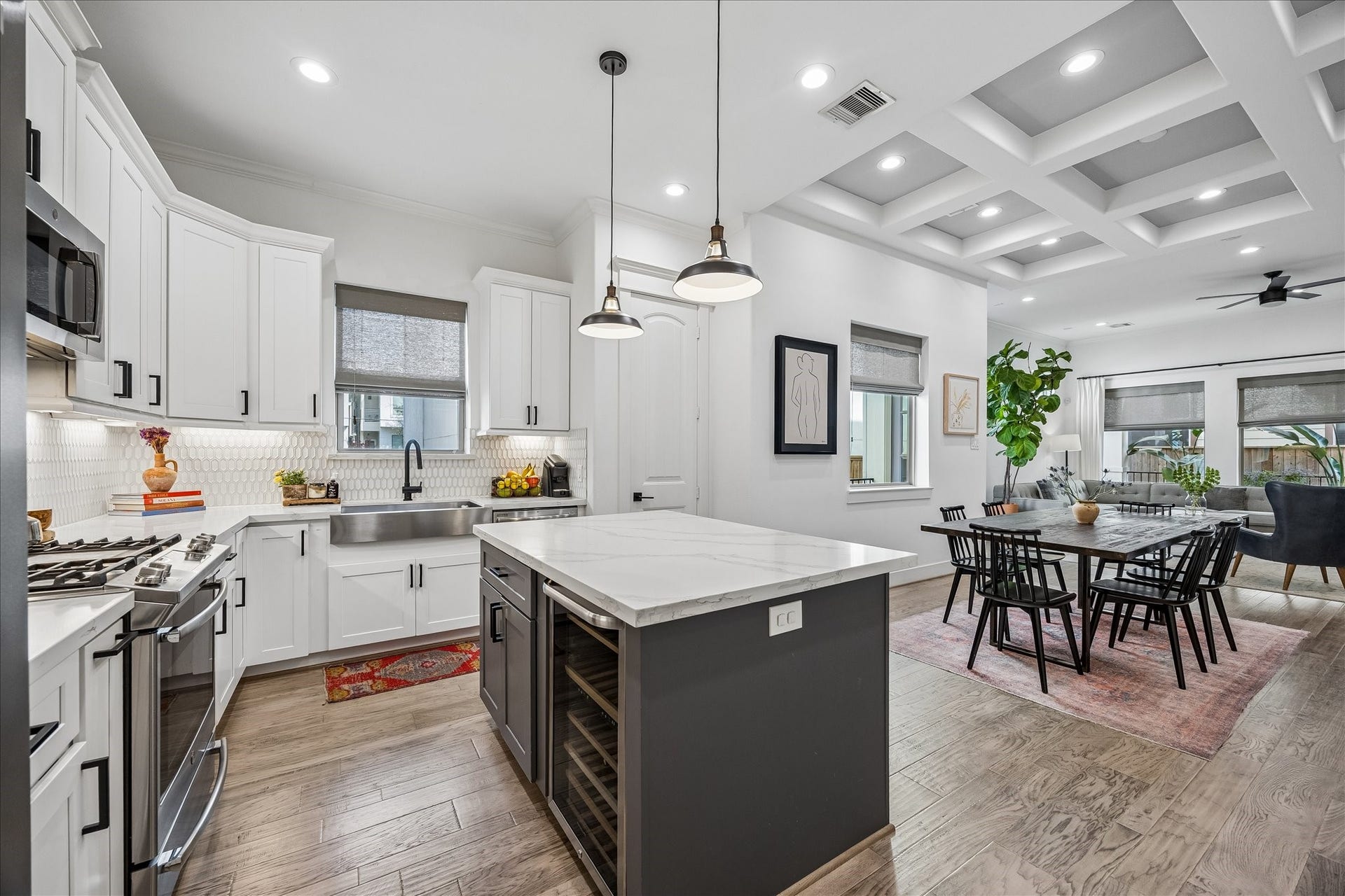 2320 Couch Street, Houston, TX 77008 The island does more than look good. It adds prep space, bar seating, extra storage, and a beverage chiller all covered in a sleek quartz top, while the open connection to the dining and living room keeps everyone part of the conversation.