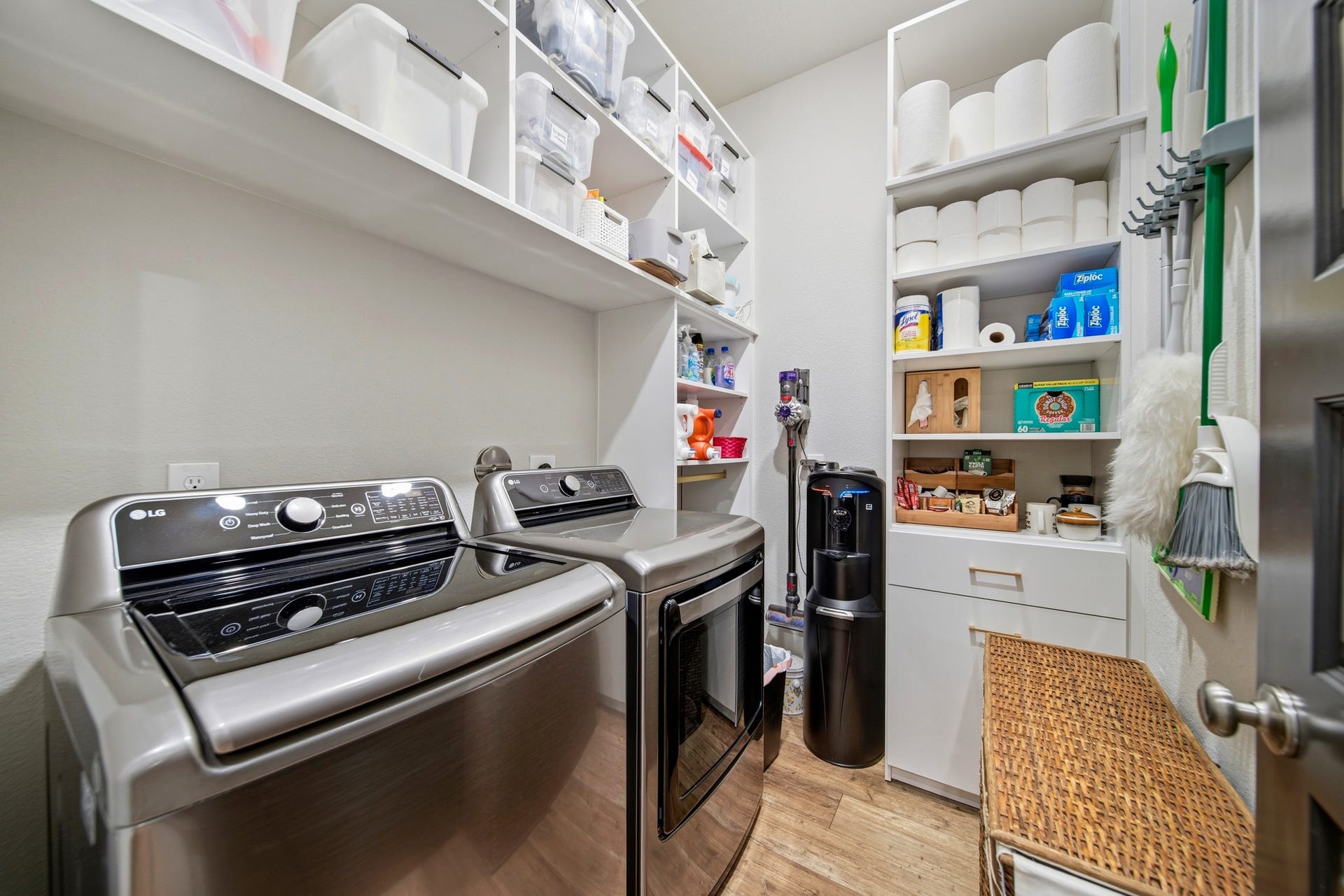 Utility/laundry room with custom shelves and cabinets. Inside the drawer is a pull-out ironing board.