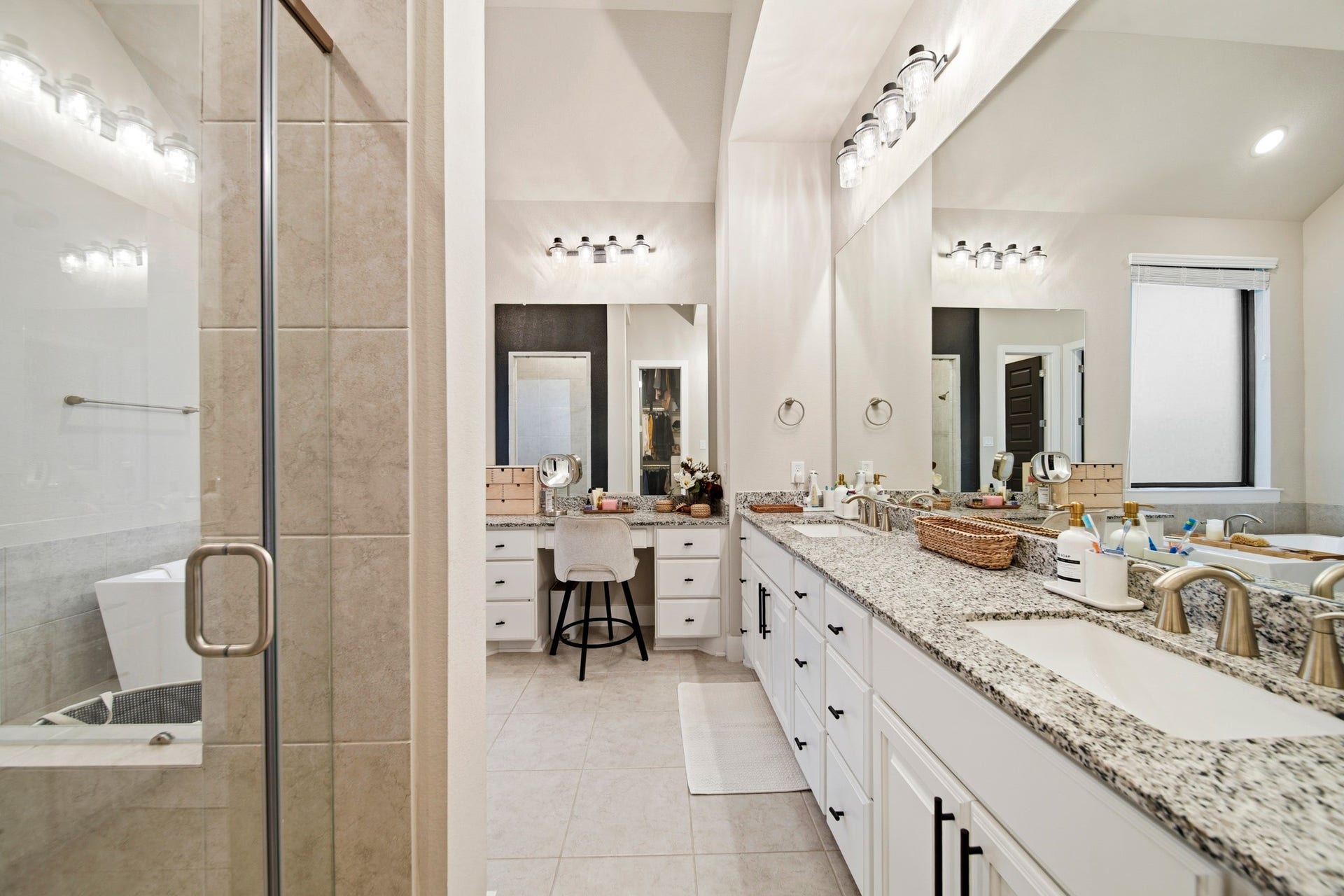 Dual vanities with granite countertops. Large walk-in shower.