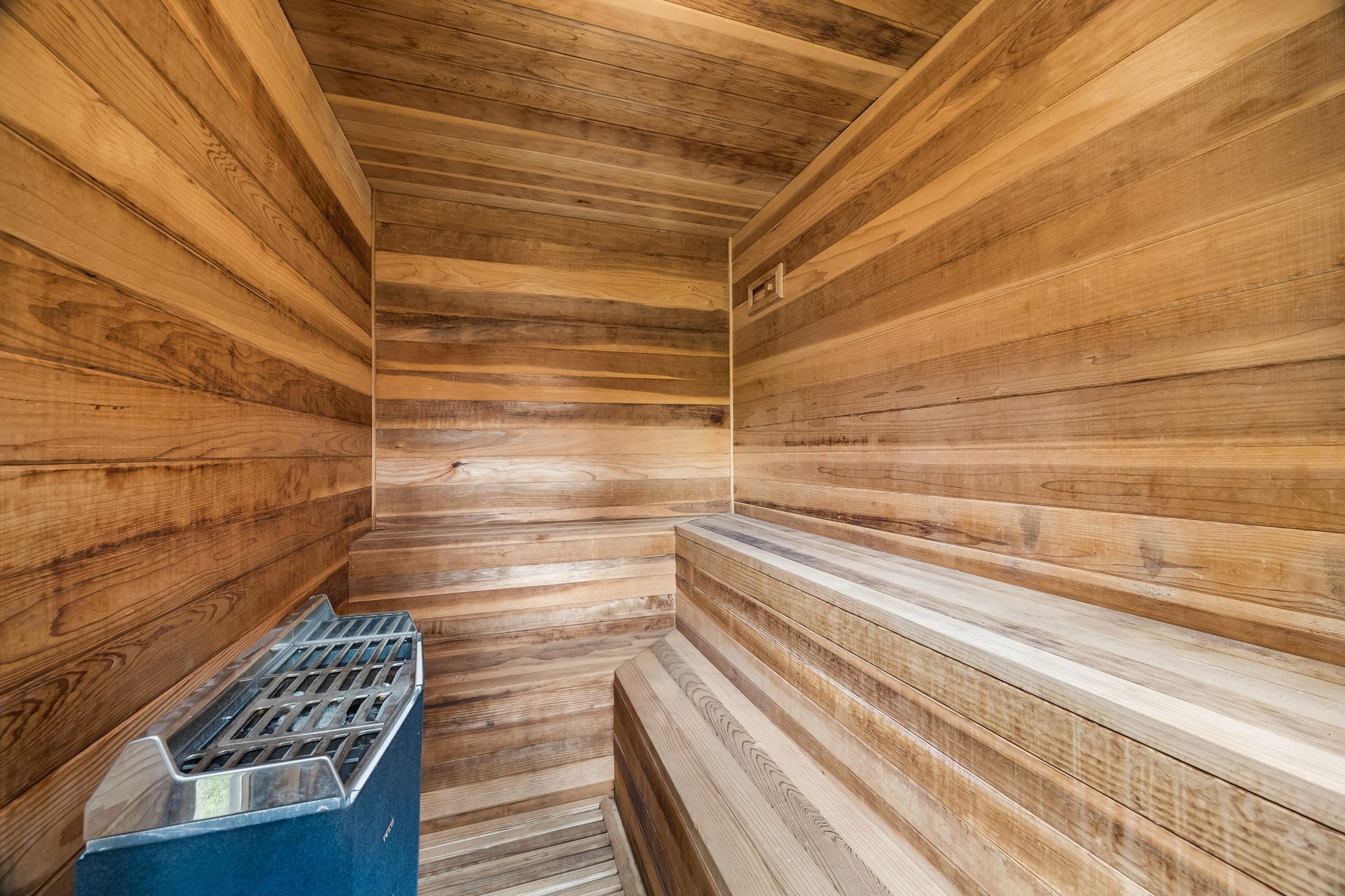 8111 Marshall Falls Drive, Spring, TX 77379 Experience ultimate relaxation in this beautifully crafted wooden sauna, featuring sleek benches and a modern heating unit for a luxurious spa experience at home.