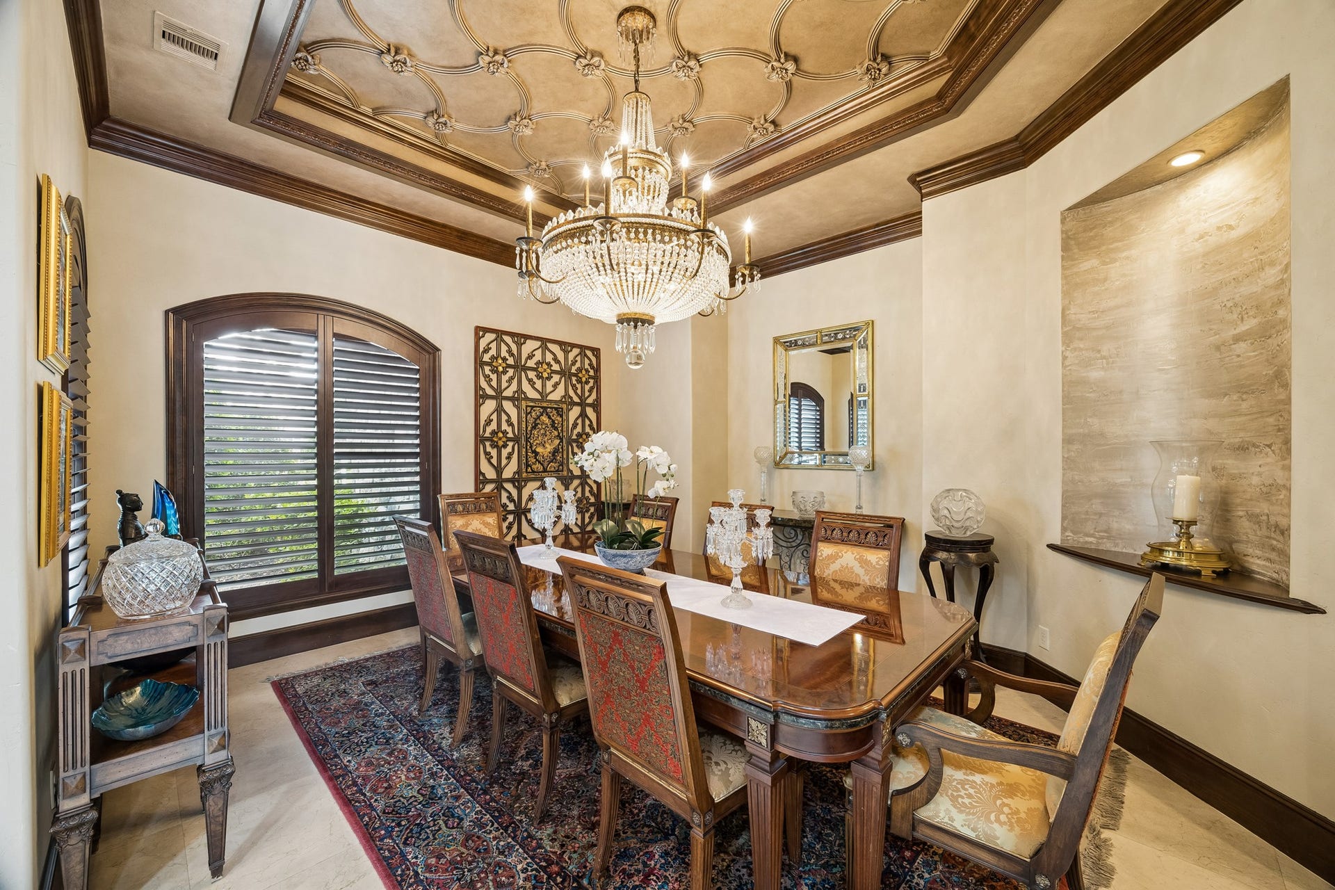 8111 Marshall Falls Drive, Spring, TX 77379 Elegant dining room featuring a stunning chandelier, intricate ceiling design, and rich wood accents, creating a warm and inviting atmosphere for entertaining.