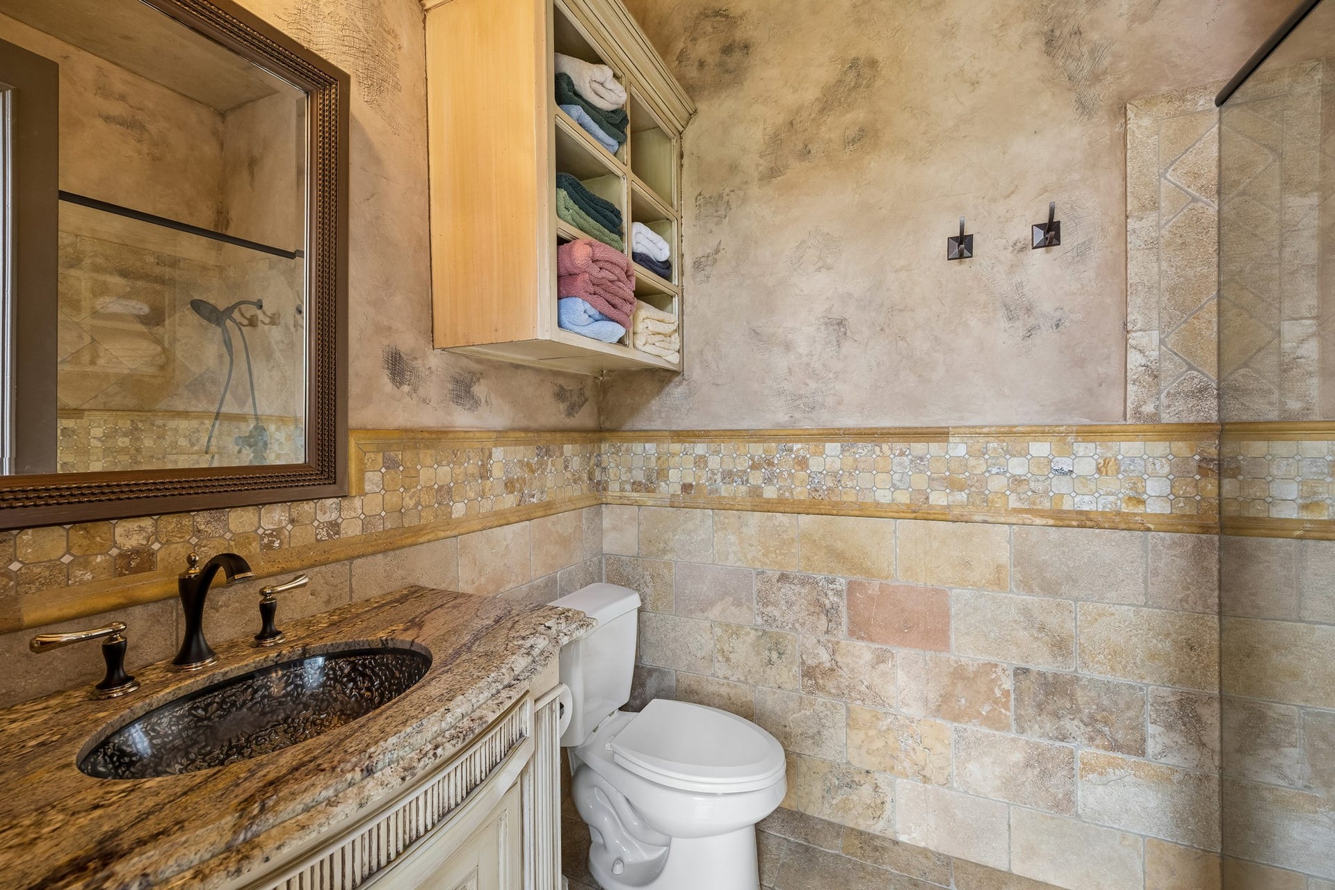 8111 Marshall Falls Drive, Spring, TX 77379 Elegant pool bathroom featuring a granite countertop, intricate tile work, and a spacious shower area, perfectly situated adjacent to the sauna.