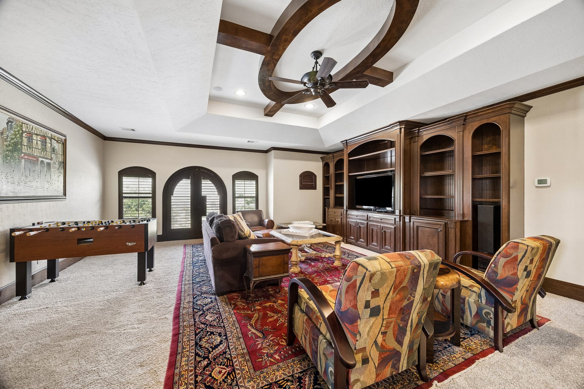 8111 Marshall Falls Drive, Spring, TX 77379 Spacious second floor game room featuring a multiple seating areas and custom built-in cabinetry, all under a beautifully detailed ceiling with a central fan.