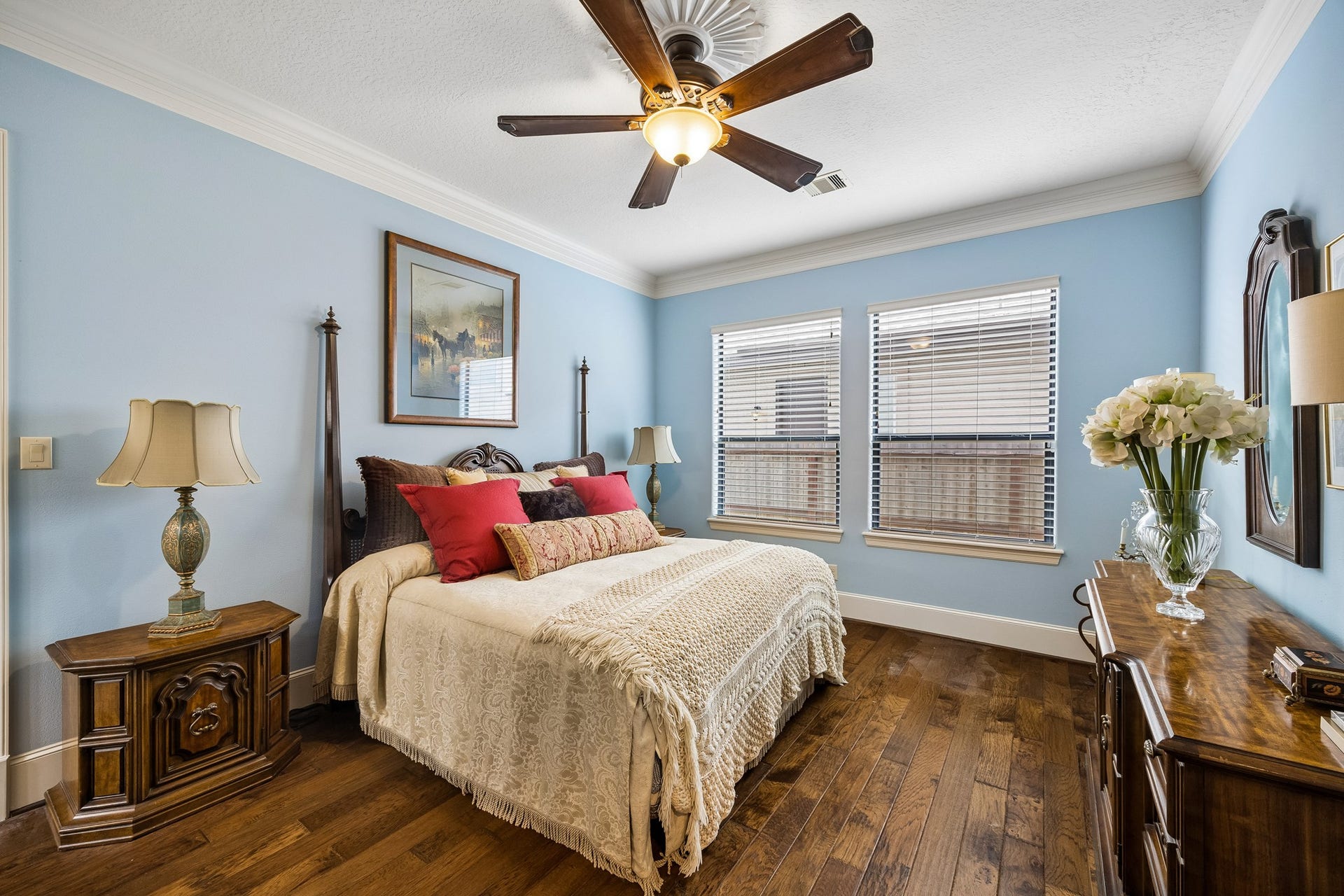 8111 Marshall Falls Drive, Spring, TX 77379 Charming first floor en-suite bedroom with soft blue walls, elegant wooden floors, and abundant natural light.