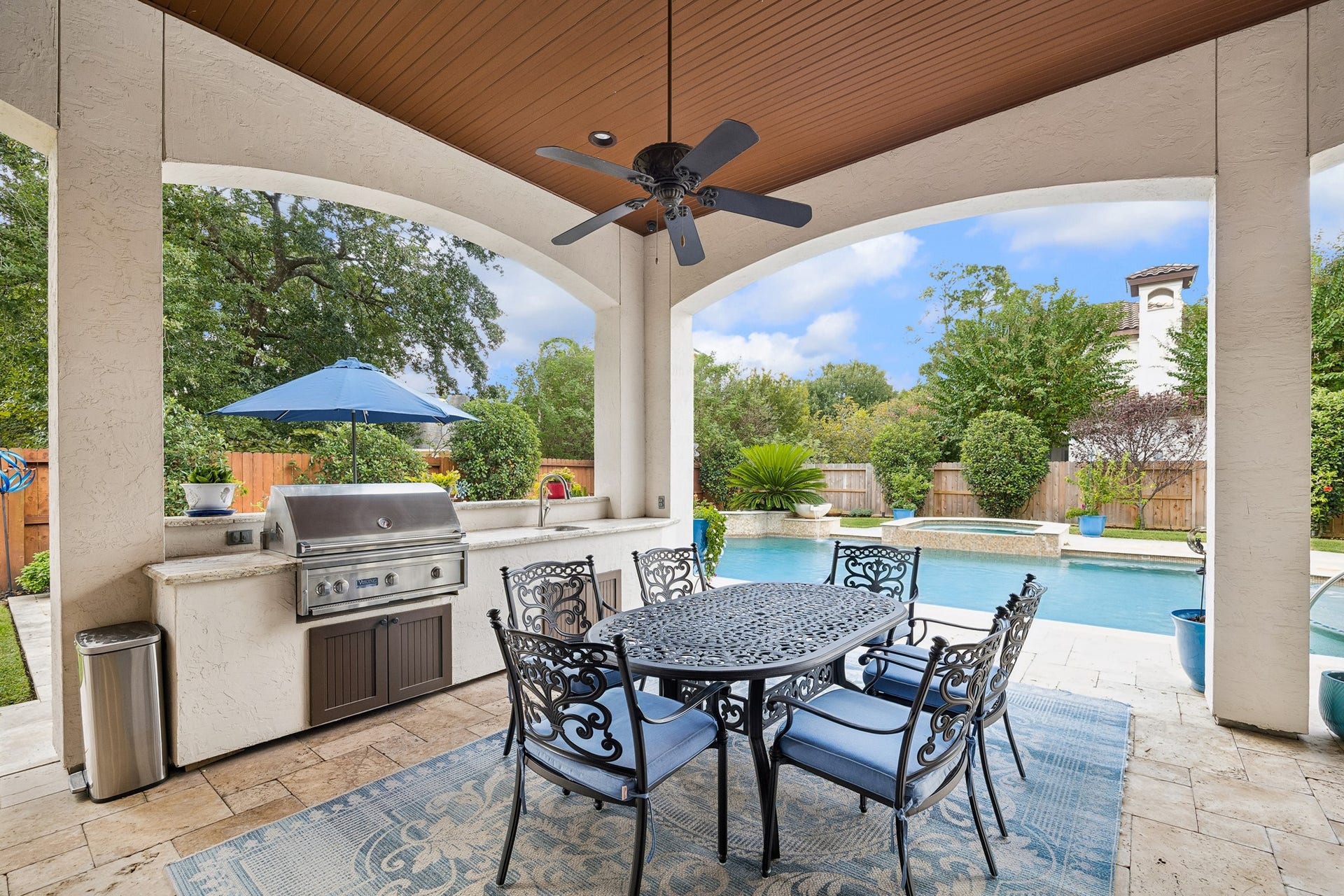 8111 Marshall Falls Drive, Spring, TX 77379 Experience luxurious outdoor living with a covered patio featuring an elegant dining area, built-in Viking grill, and views of a sparkling pool surrounded by lush landscaping.