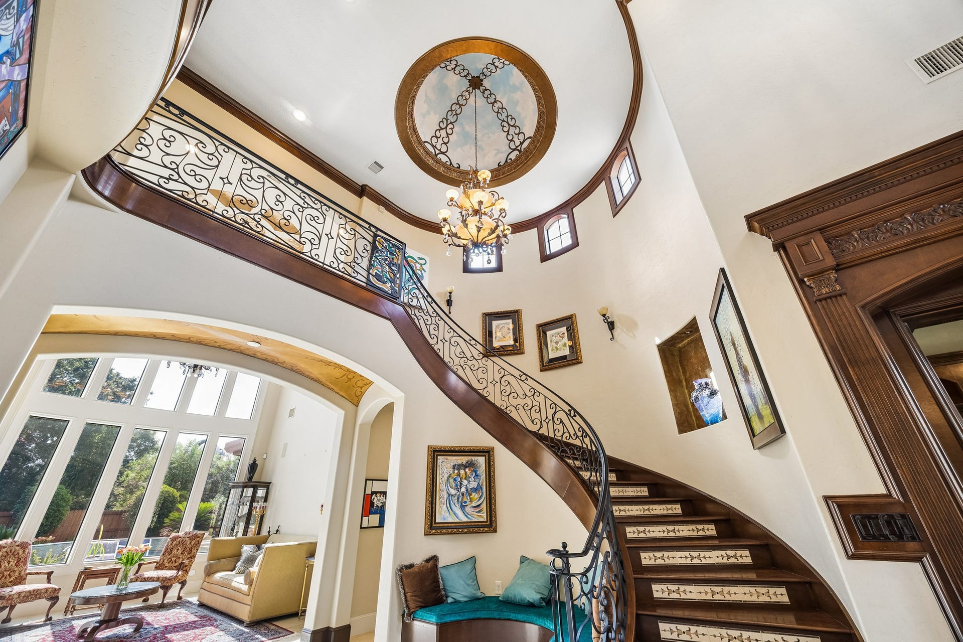 8111 Marshall Falls Drive, Spring, TX 77379 Elegant curved staircase with intricate wrought iron railing, leading to the spacious second floor. Note the beautiful ceiling treatment and chandelier.
