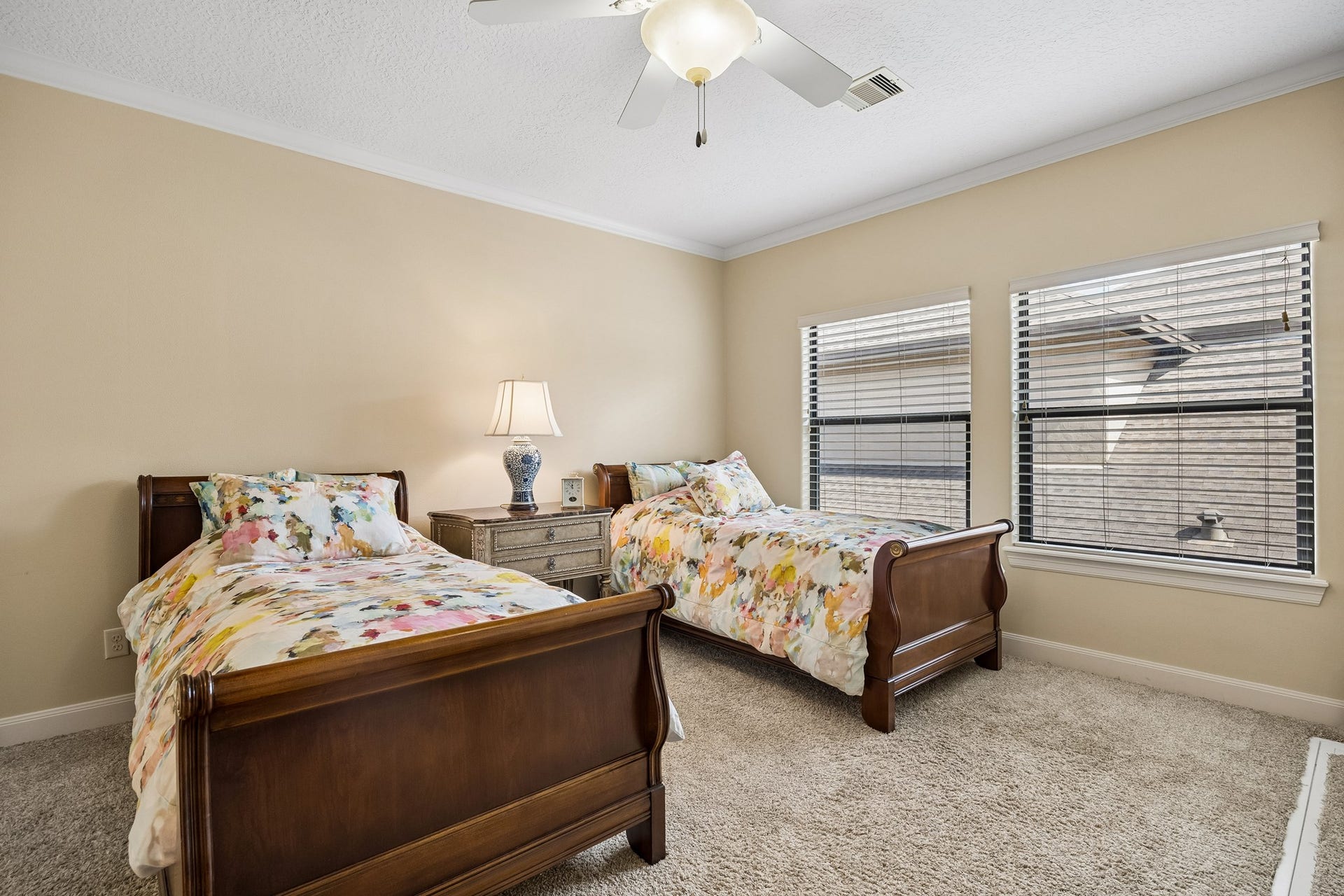 8111 Marshall Falls Drive, Spring, TX 77379 Spacious second floor bedroom with en-suite bathroom, warm neutral walls, and soft carpeting, illuminated by natural light from two large windows.
