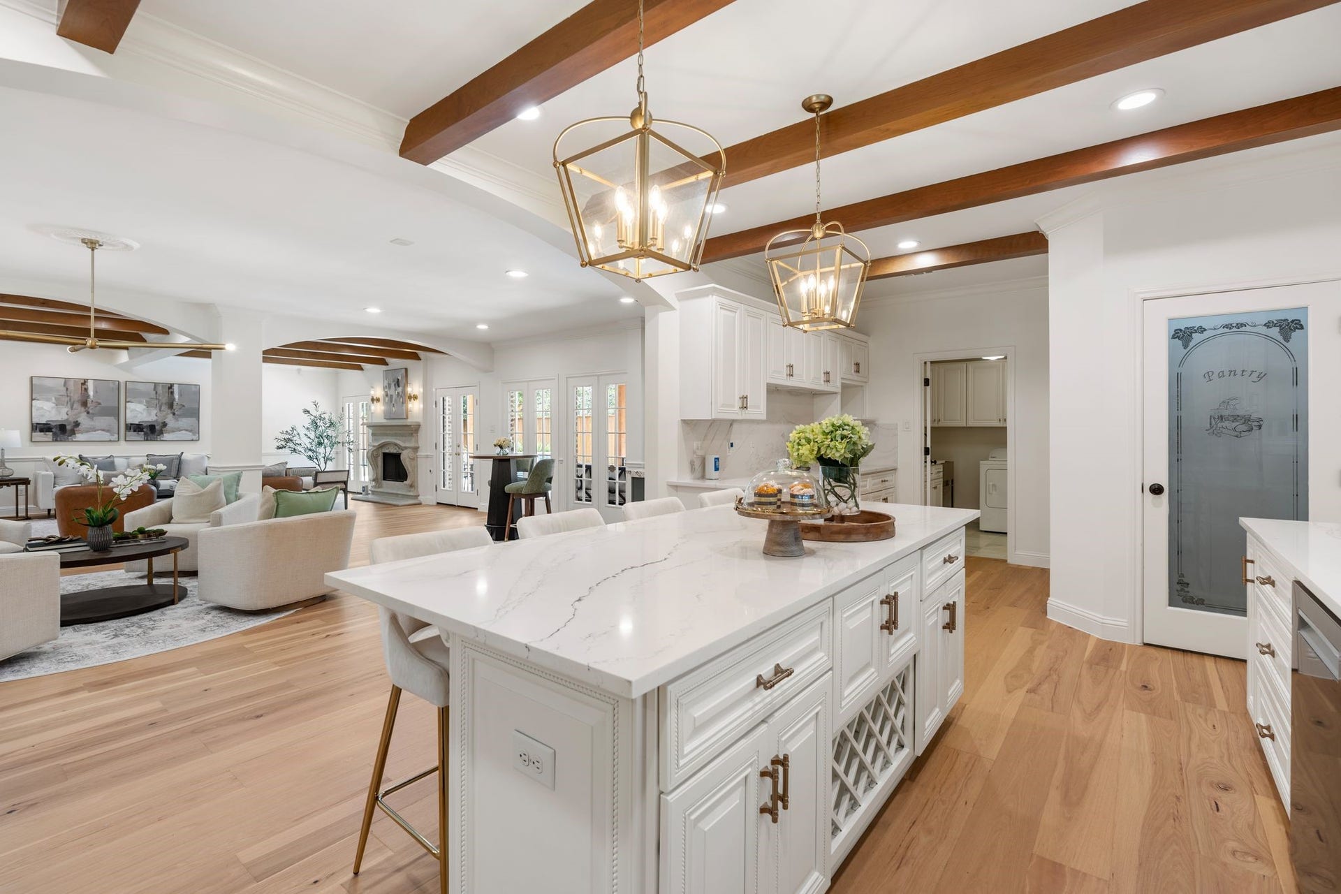 11407 Holidan Way, Hedwig Village, TX 77024 Another perspective highlights the kitchens seamless connection to the breakfast area & adjoining living spaces. Oversized island provides generous prep space, seating & storage, while newer accent wood ceiling beams add warmth overhead.