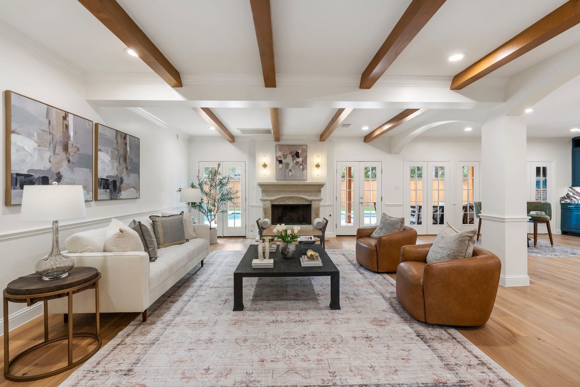 11407 Holidan Way, Hedwig Village, TX 77024 Spacious living room beautifully centered around an ornate carved stone fireplace & mantel. French doors overlook the backyard & pool, creating a beautiful indoor-outdoor connection. New Premium Engineered Hickory wood flooring (26), carries throughout the first-floor living spaces, while the open connection to the entry and main living spaces creates an effortless flow through the home.