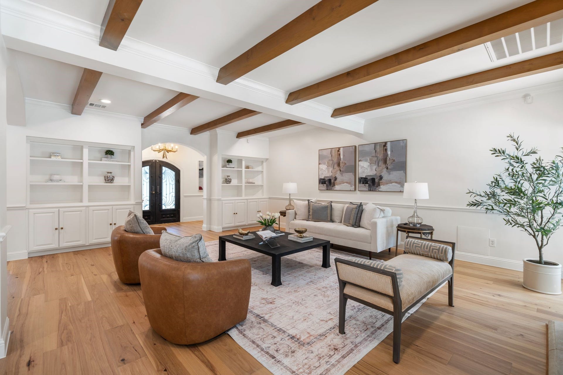 11407 Holidan Way, Hedwig Village, TX 77024 Another perspective of the expansive living room showcasing the generous scale & reimagined open floor plan. Dual sets of built-in display/bookshelves provide additional storage, while accent wood ceiling beams add warmth & architectural character.