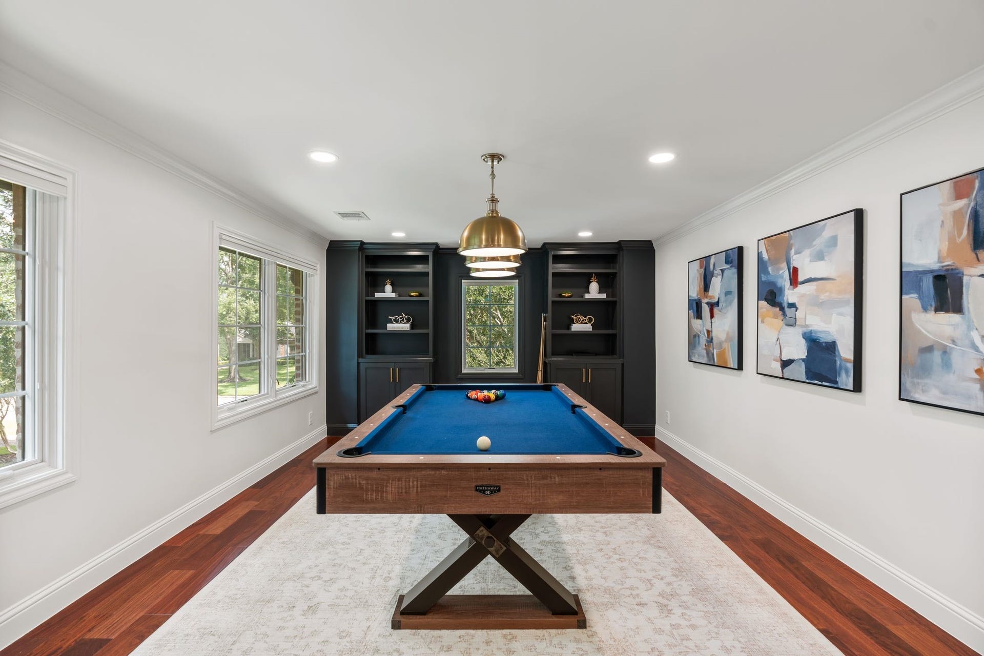 11407 Holidan Way, Hedwig Village, TX 77024 Closer view of the dedicated billiards/play area anchored by the pool table, which remains w/ the home. Decorative pendant lighting above & surrounding built-in cabinetry create a polished setting for entertaining, while the generous room size can easily accommodate additional game furniture.