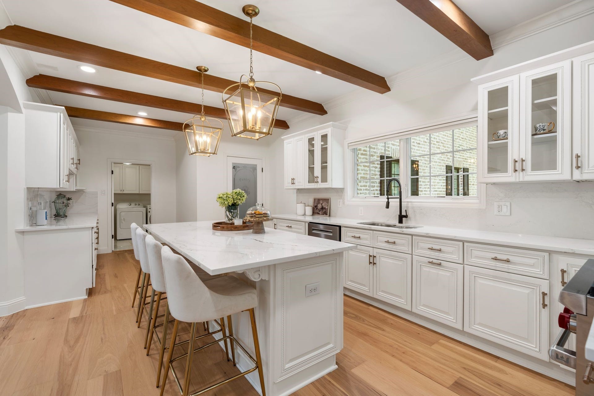 11407 Holidan Way, Hedwig Village, TX 77024 Stunning fully-equipped chefs kitchen extensively remodeled in 2024. Anchored by an oversized island w/ breakfast bar seating, storage & built-in wine rack. Cambria Lakedale quartz countertops & backsplash, abundant soft-close cabinetry, decorative pendants & a walk-in pantry beautifully combine function & style.