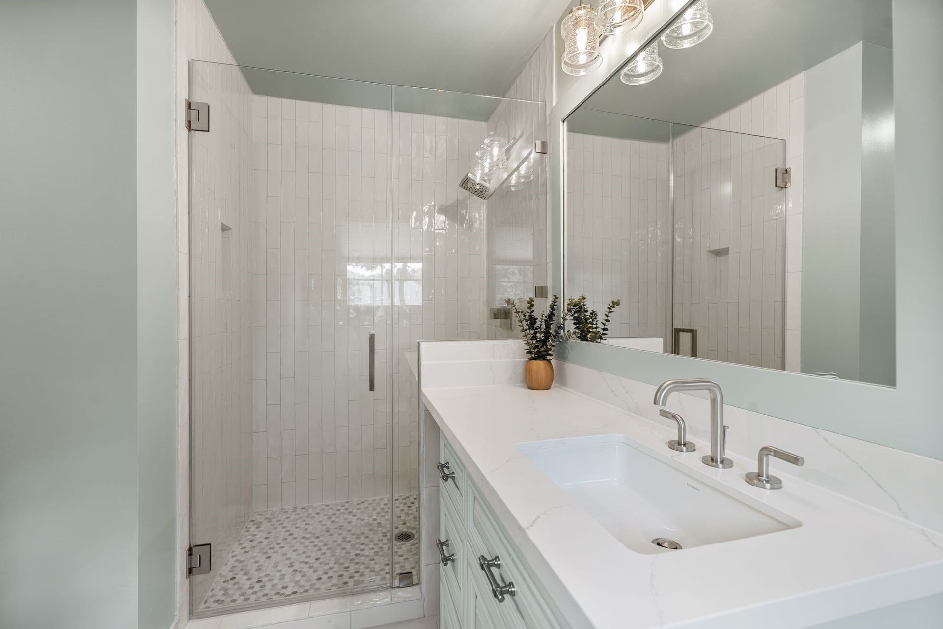 11407 Holidan Way, Hedwig Village, TX 77024 Private en suite bath created for Secondary Bedroom #2 in 2025. Features a vanity w/ quartz countertop & storage, frameless glass shower w/ decorative tile flooring & surround, plus access to a large remodeled walk-in closet.