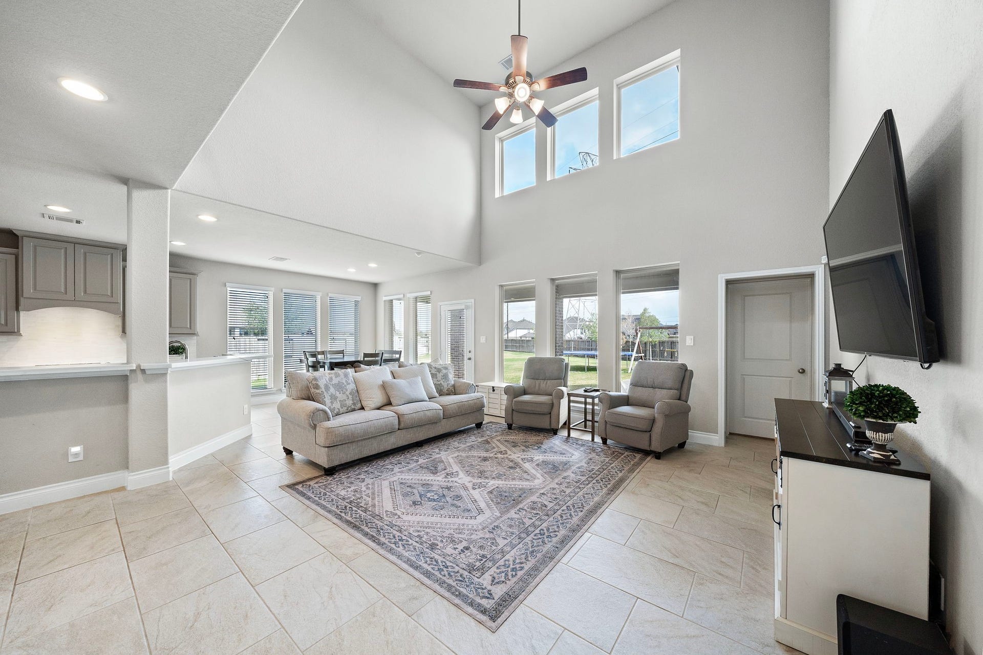 6902 N Elmwood Trail, Katy, TX 77493 Spacious living area with high ceilings and ample natural light, featuring modern furnishings and an open layout connecting to the kitchen and dining area.