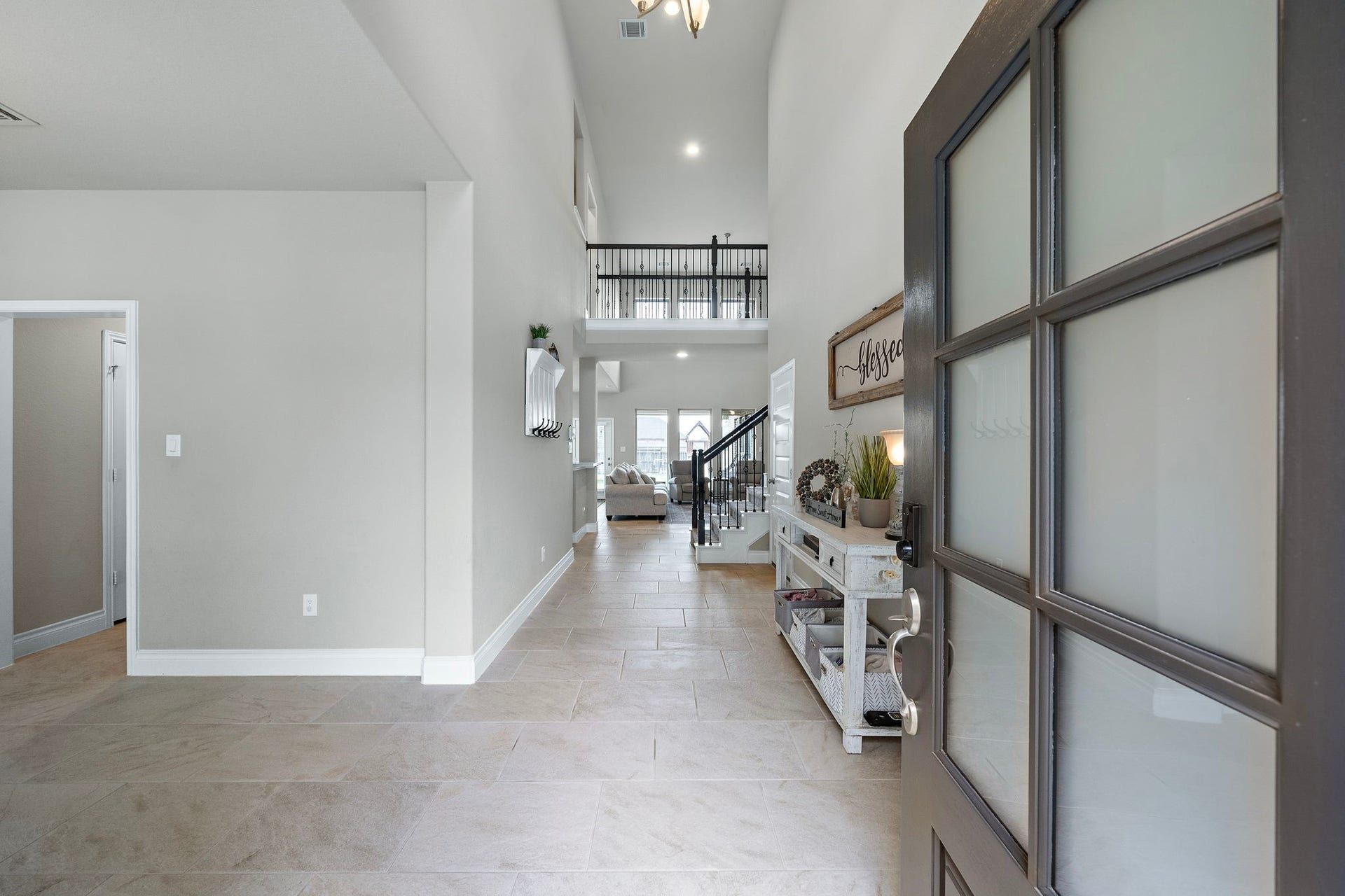 6902 N Elmwood Trail, Katy, TX 77493 Step into a bright and inviting entryway featuring soaring ceilings and modern tile flooring, creating a welcoming first impression as it flows seamlessly into the open-concept living area.