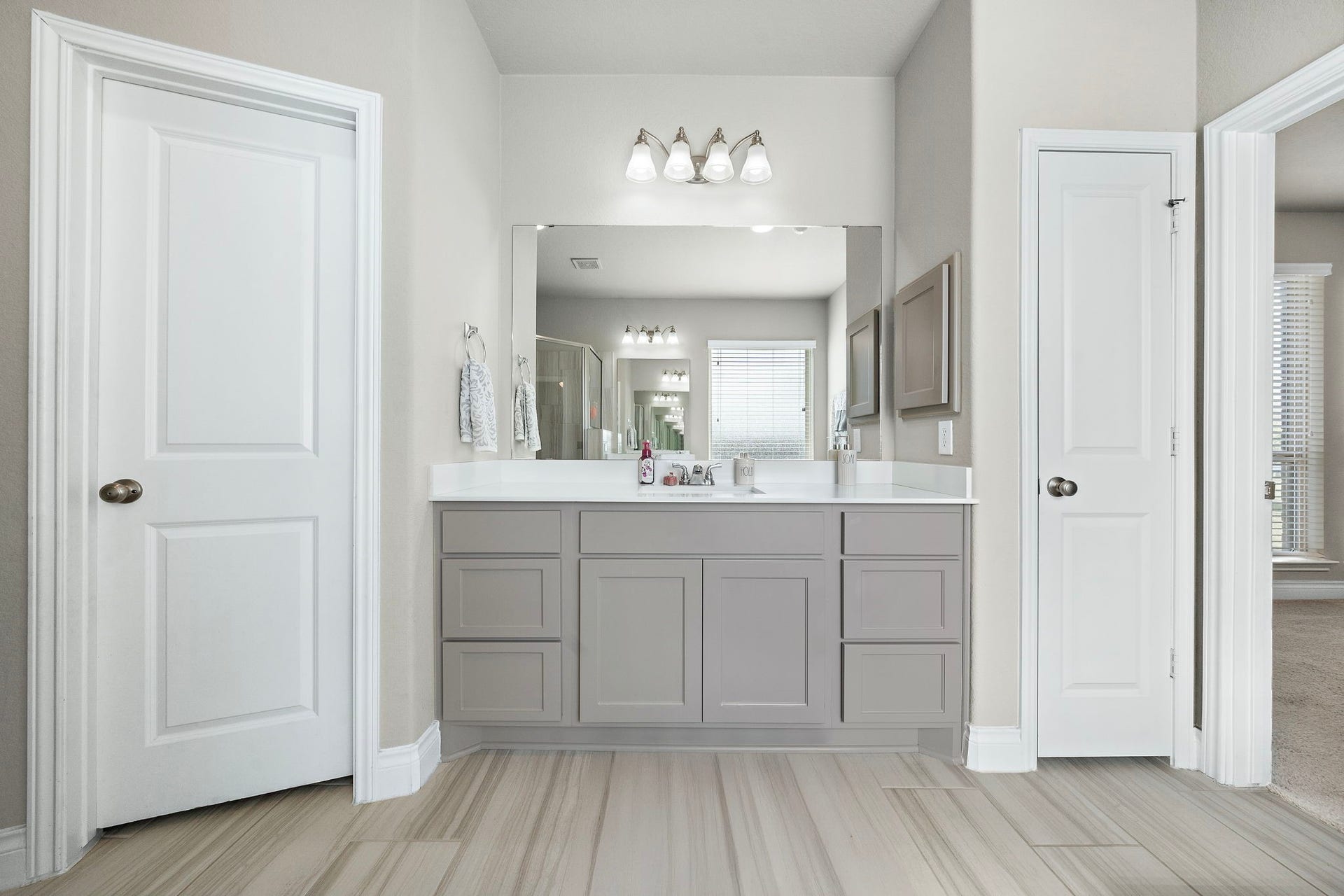 6902 N Elmwood Trail, Katy, TX 77493 Spacious bathroom featuring a sleek double vanity with ample storage, modern lighting, and stylish tile flooring, offering a blend of functionality and elegance.