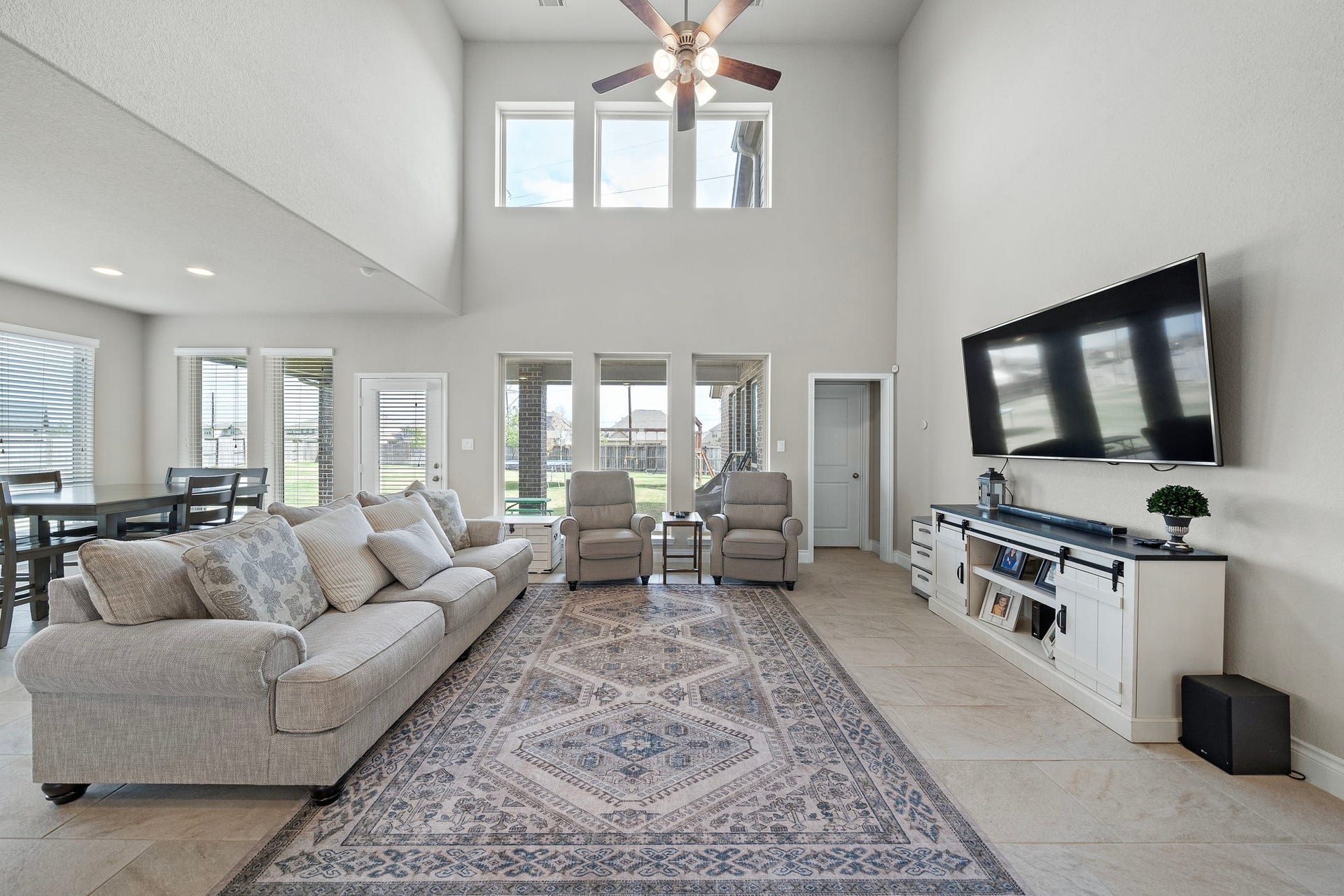 6902 N Elmwood Trail, Katy, TX 77493 A spacious living room featuring dramatic two-story ceilings, abundant natural light from oversized windows and an expansive open layout with plenty of room for comfortable seating and entertaining.