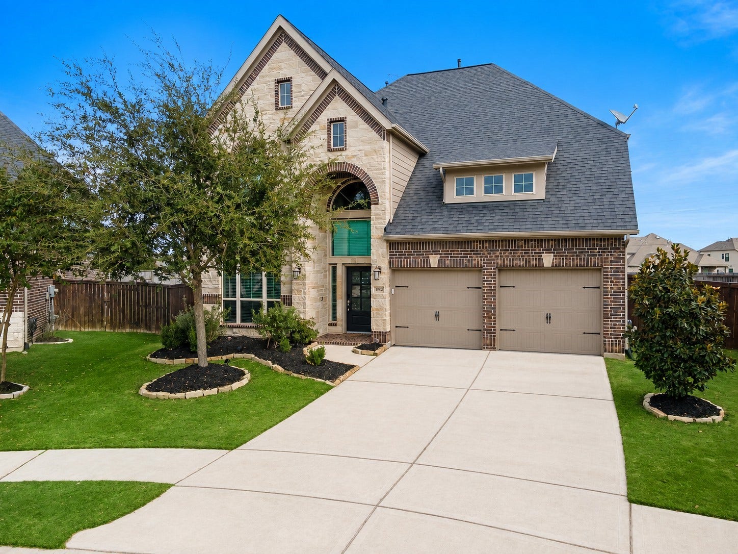 6902 N Elmwood Trail, Katy, TX 77493 Stunning two-story brick home with charming gables, a spacious two-car garage, and well-manicured landscaping.