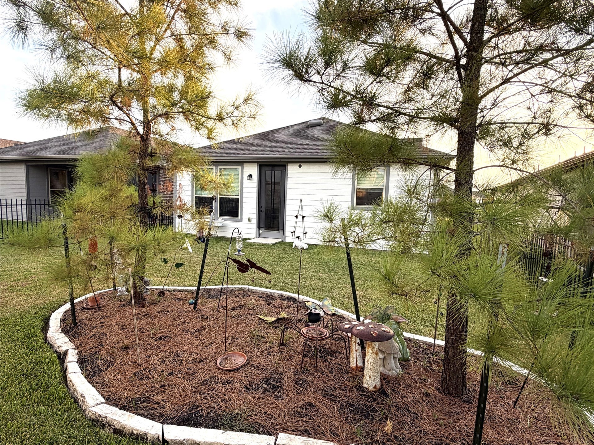 8015 Prospect Drive, Fulshear, TX 77441 Enjoy a peaceful backyard setting with mature trees and thoughtfully landscaped garden beds. A charming outdoor space perfect for nature lovers and quiet moments of relaxation.