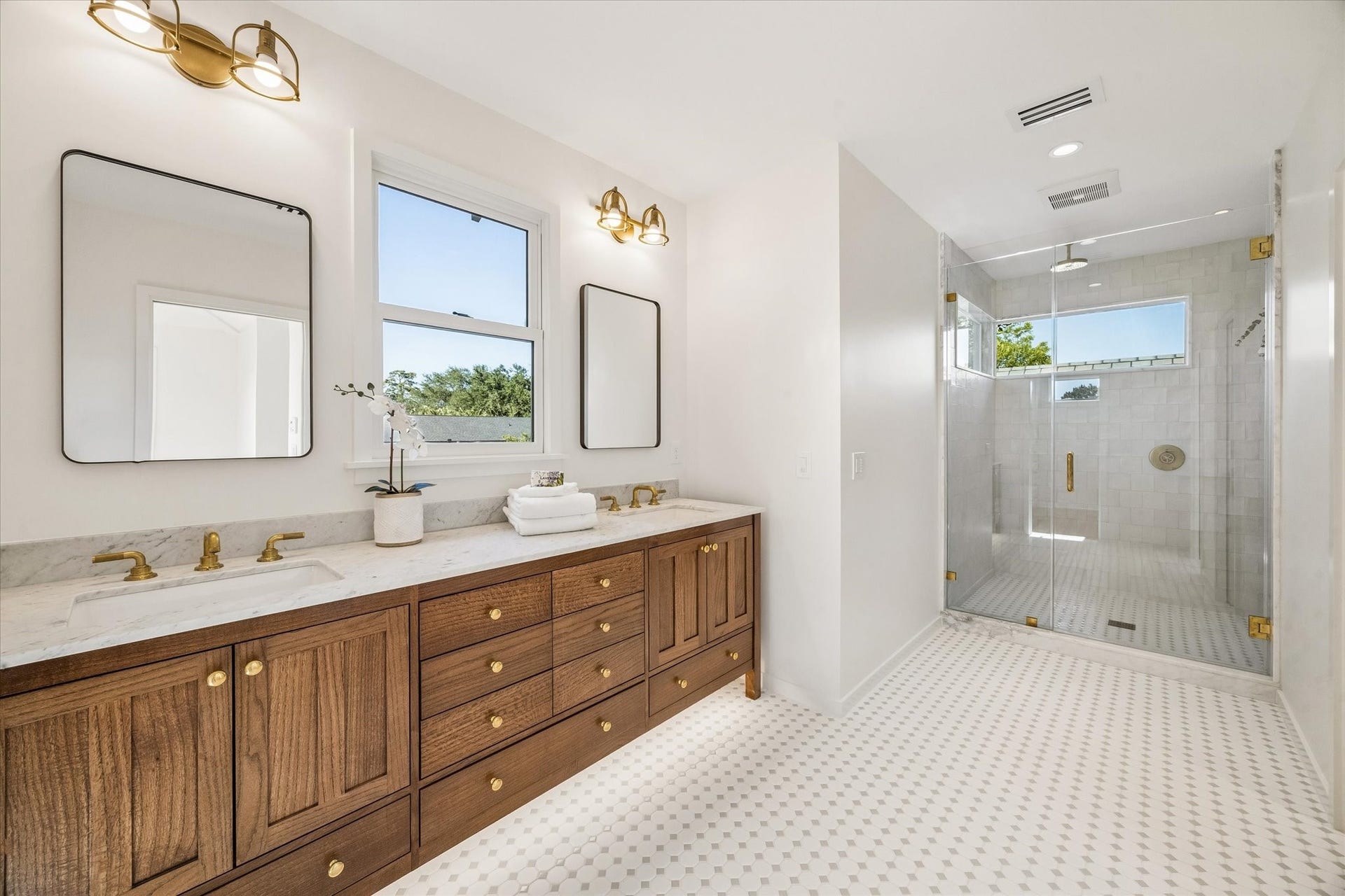 1203 Heights Boulevard, Houston, TX 77008 Primary Bath has dual sinks and a large walk in shower. The vanity is made for the oak tree accented with polished brass hardware.
