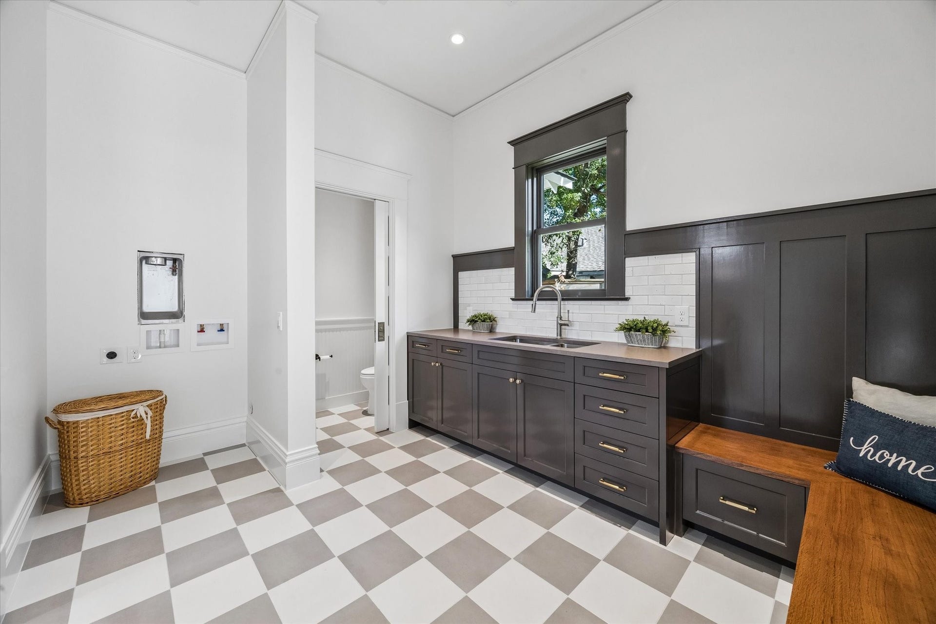 1203 Heights Boulevard, Houston, TX 77008 The utility/laundry & W/C. has a delightful tile floor. Washer/Dryer ready, extra sink and counter top with storage painted in rich grey tone plus a bench to kick off your shoes.