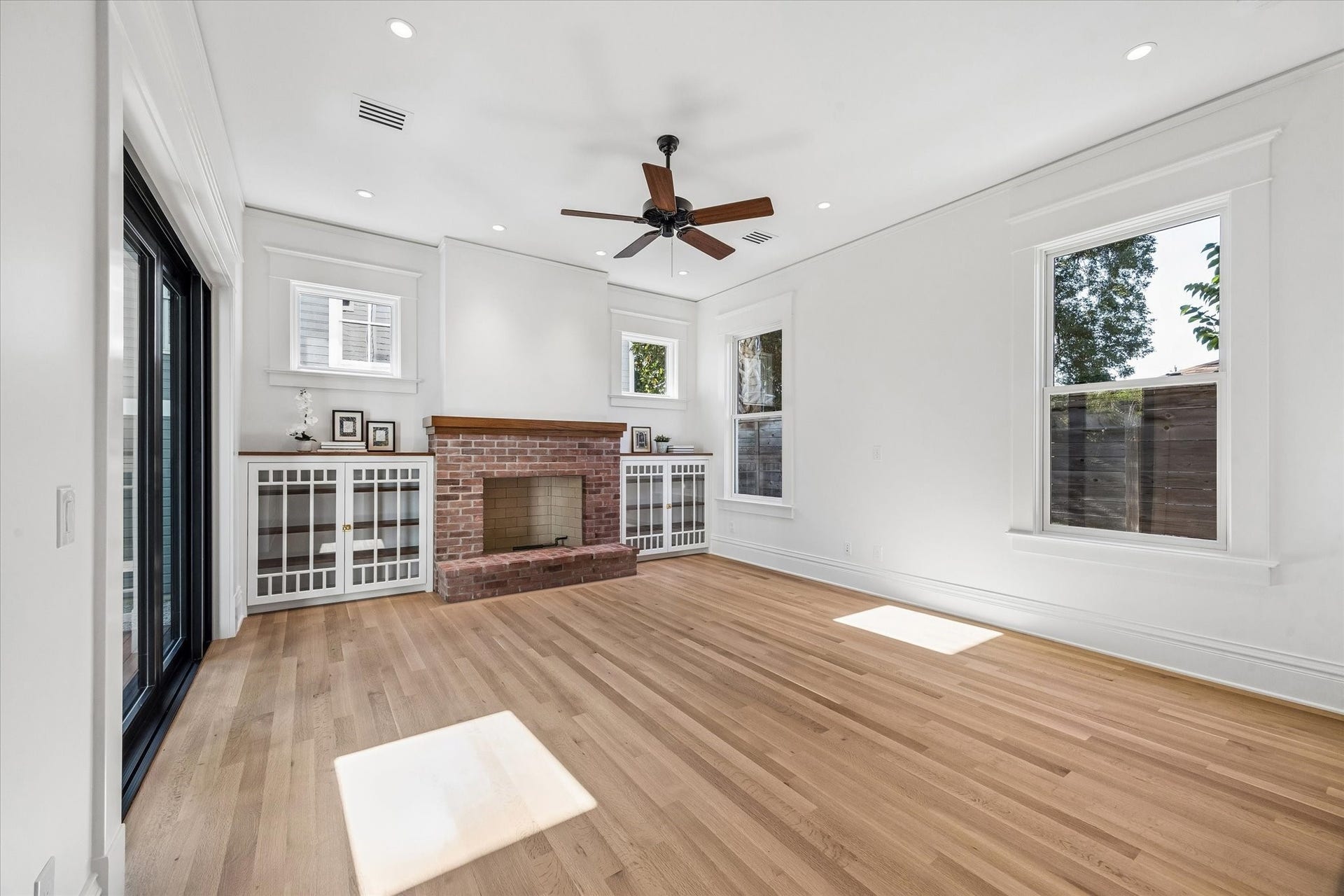 1203 Heights Boulevard, Houston, TX 77008 The family room has a wood burning fire place made from repurposed brick from the original fireplace and custom glass doors bookshelves. The mantel and the tops of the bookcases are made from oak tree that was salvage from this property.