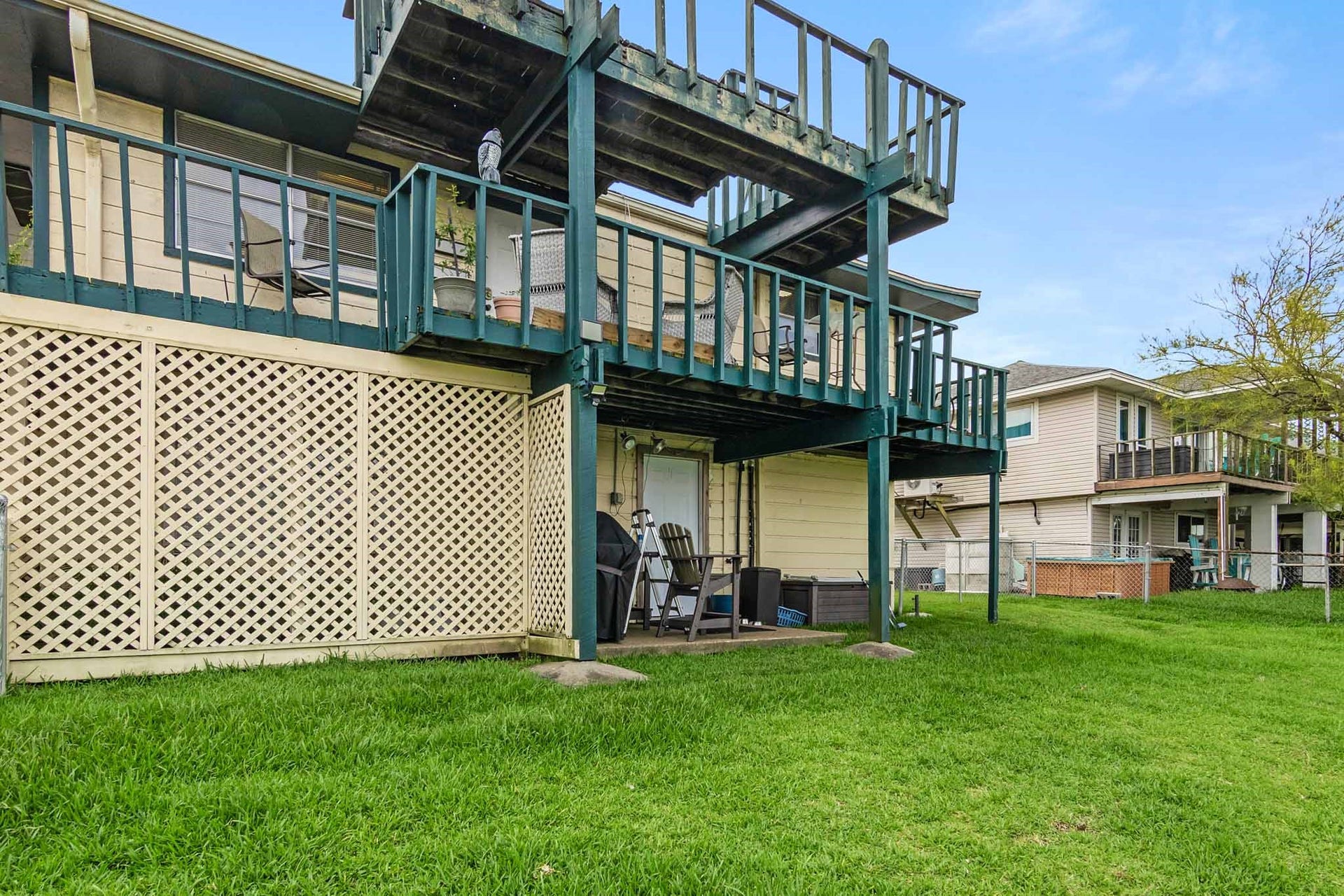 856 Bonita Street, Bayou Vista, TX 77563 Canal side of home showing small patio on first level and decks on second and third level.