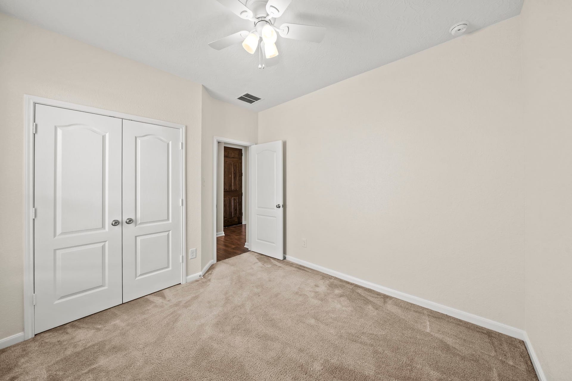 8908 Bear Mountain Court, Magnolia, TX 77354 Spacious secondary bedroom featuring comfortable plush carpeting, a bright ceiling fan light, and neutral finishes.