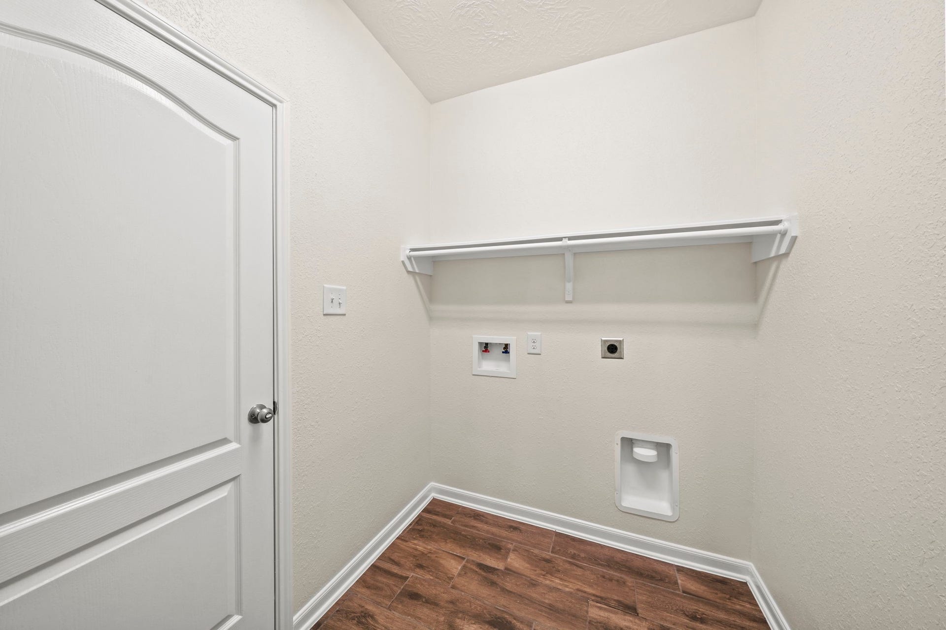 8908 Bear Mountain Court, Magnolia, TX 77354 Convenient in-house laundry room with full wood-look tile flooring, and built-in upper shelving for supply storage.