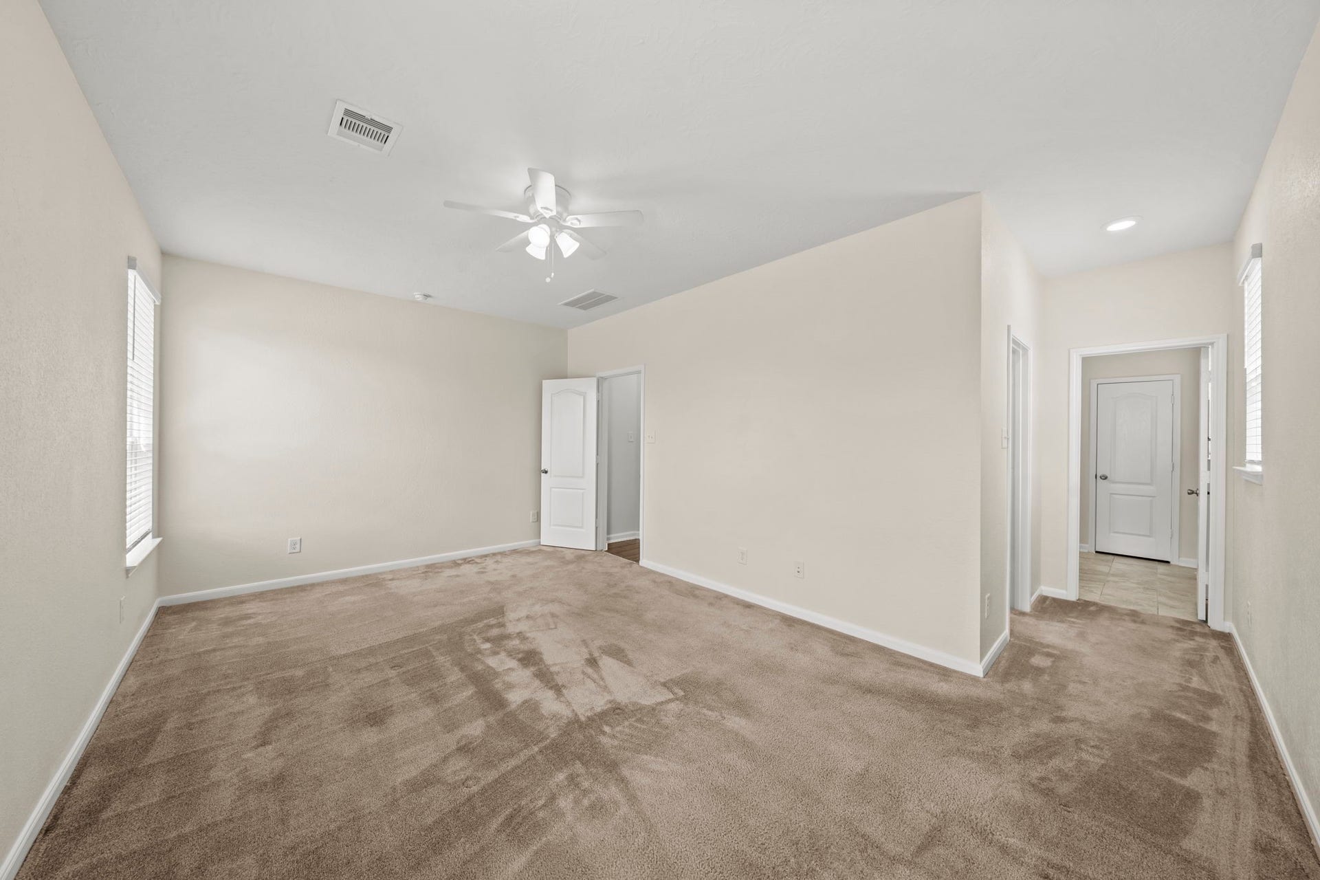 8908 Bear Mountain Court, Magnolia, TX 77354 Generously primary bedroom featuring plush carpeting, a ceiling fan, and neutral tones.