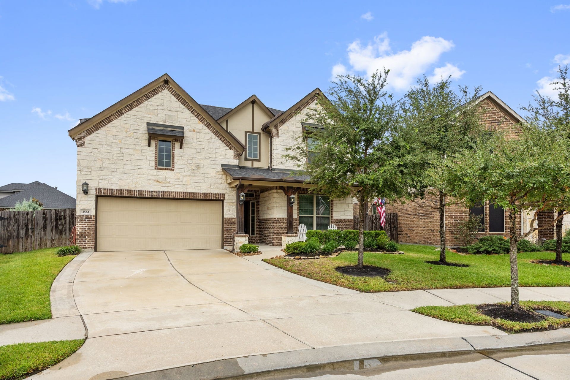 Charming two-story home with a stone and brick facade, featuring a spacious two-car garage.