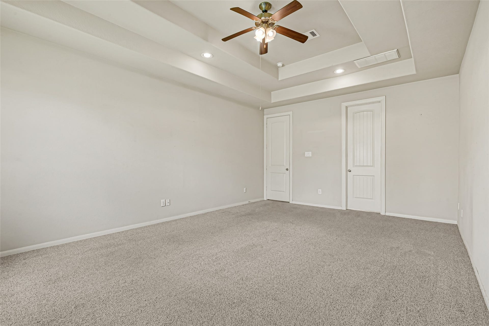 736 Somerset Landing Lane, League City, TX 77573 Spacious bedroom with tray ceiling, ceiling fan, neutral carpet, and abundant natural light.