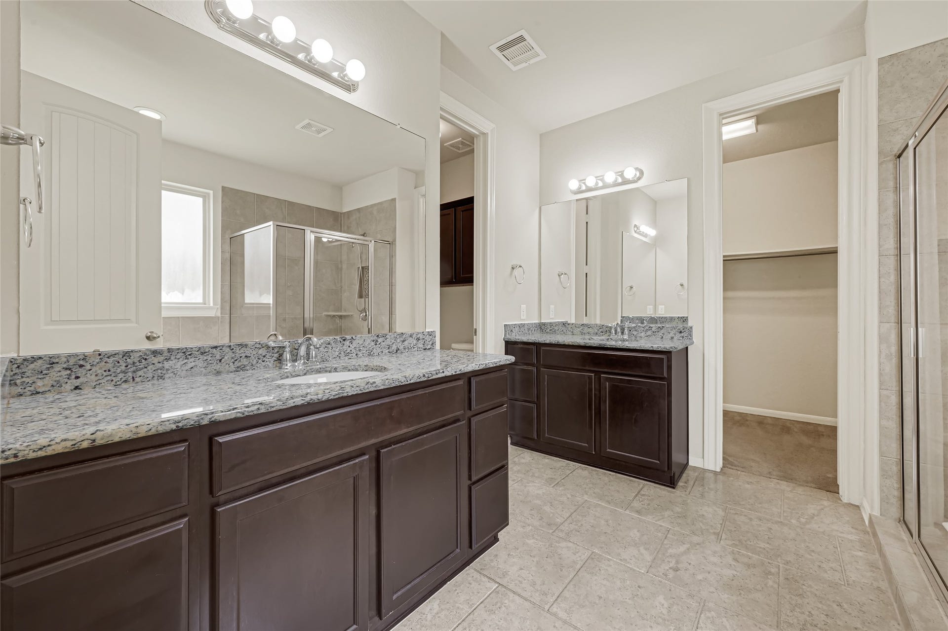 736 Somerset Landing Lane, League City, TX 77573 Expansive bathroom vanity with dark cabinetry, dual sinks, large mirrors, and abundant counterspace.