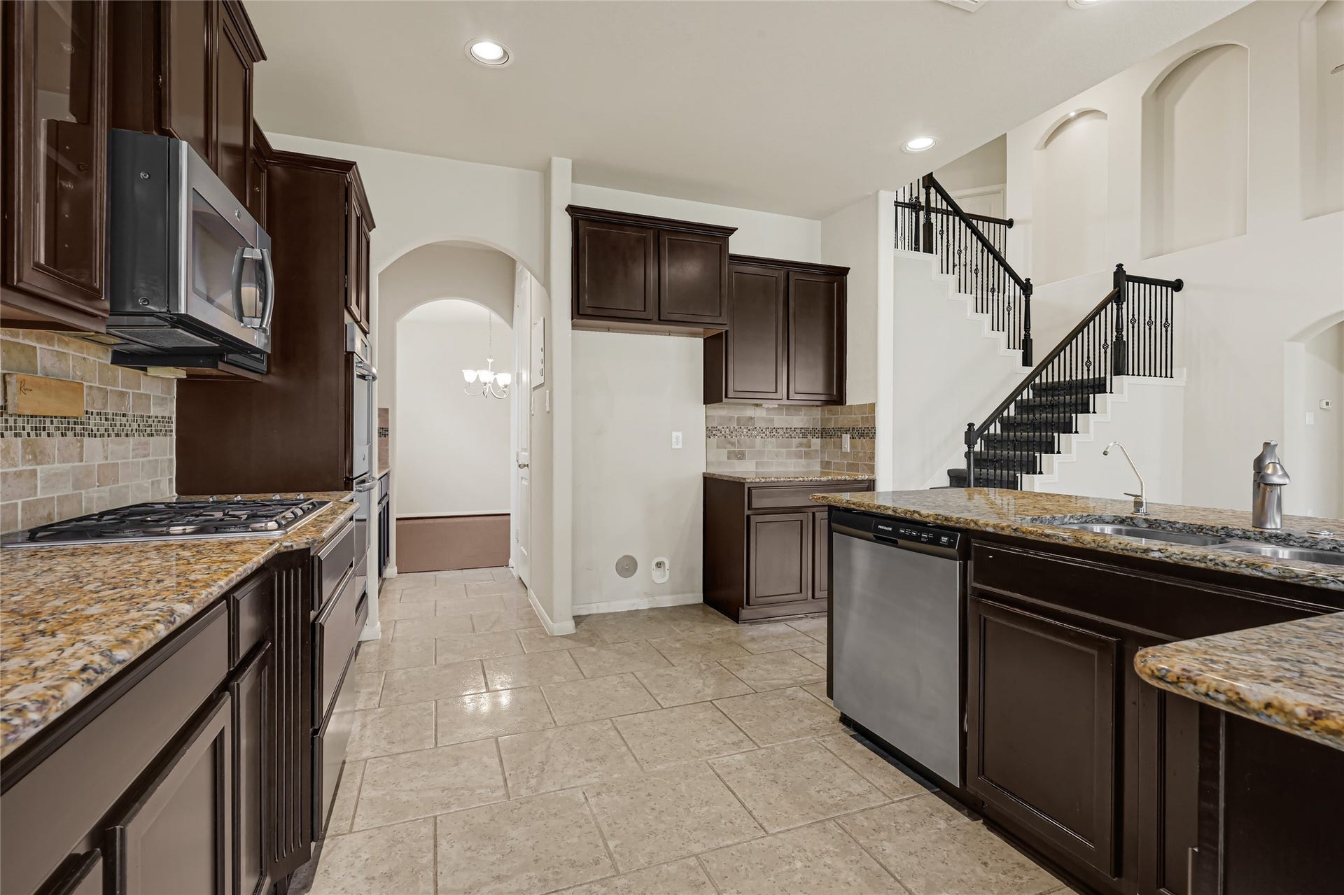 736 Somerset Landing Lane, League City, TX 77573 Spacious kitchen with dark cabinetry, granite countertops, stainless steel appliances, and an open layout.