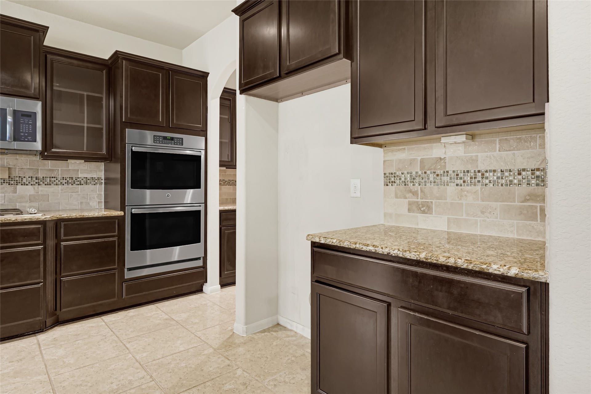 736 Somerset Landing Lane, League City, TX 77573 Built-in double ovens, extensive cabinetry, granite counters, and a tiled backsplash