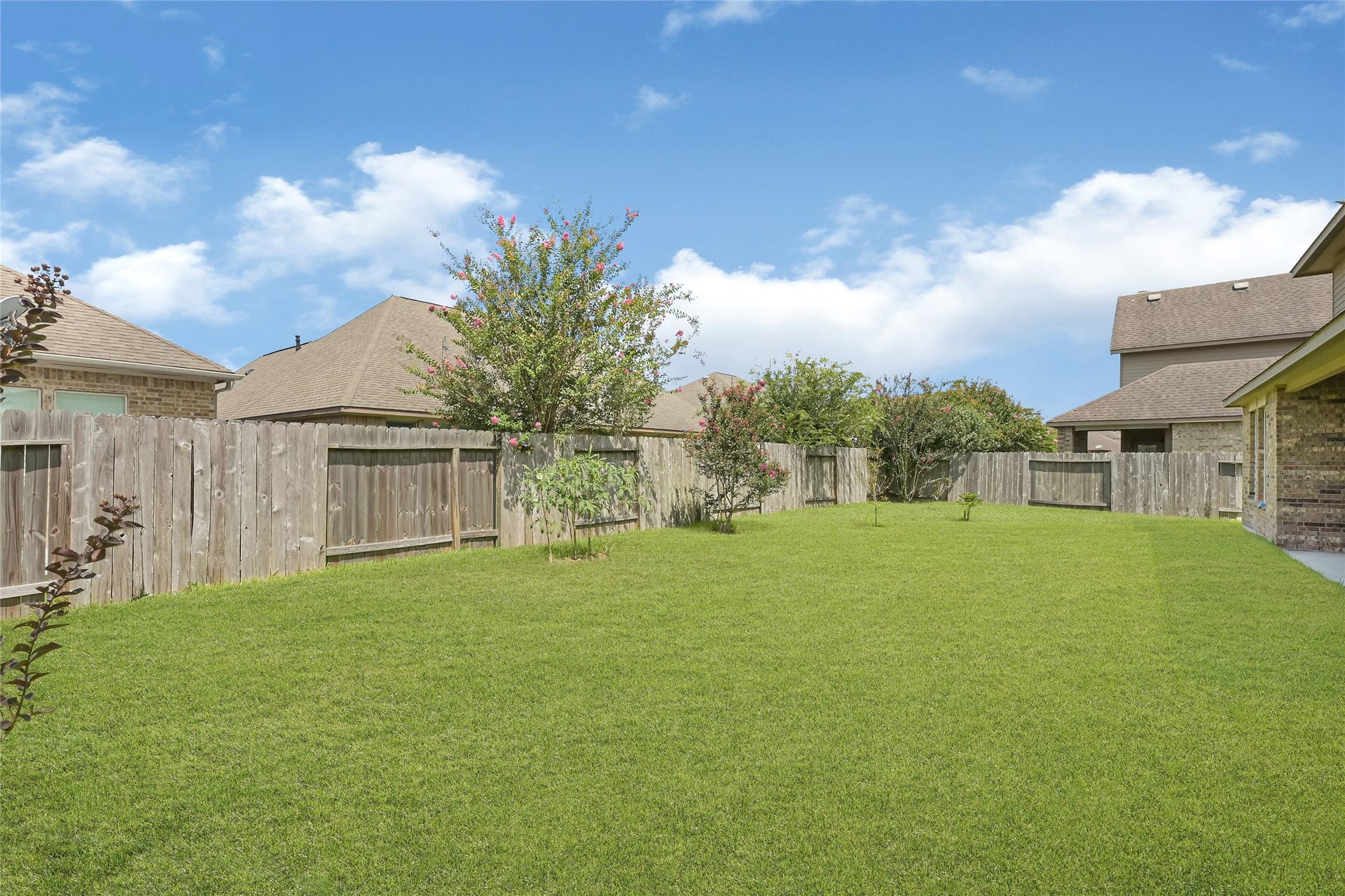 736 Somerset Landing Lane, League City, TX 77573 Spacious backyard with a full view of the homes brick exterior and multiple windows