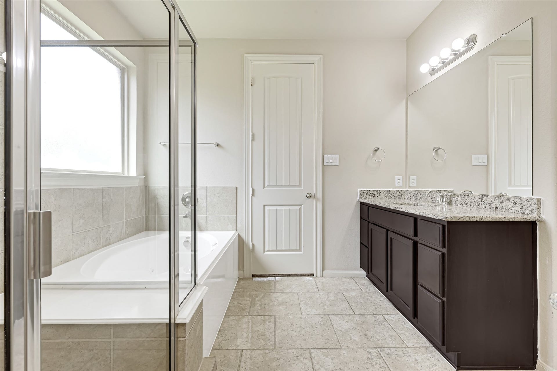 736 Somerset Landing Lane, League City, TX 77573 Bright primary bath with a large soaking tub, separate shower, dual vanities, and generous natural light.