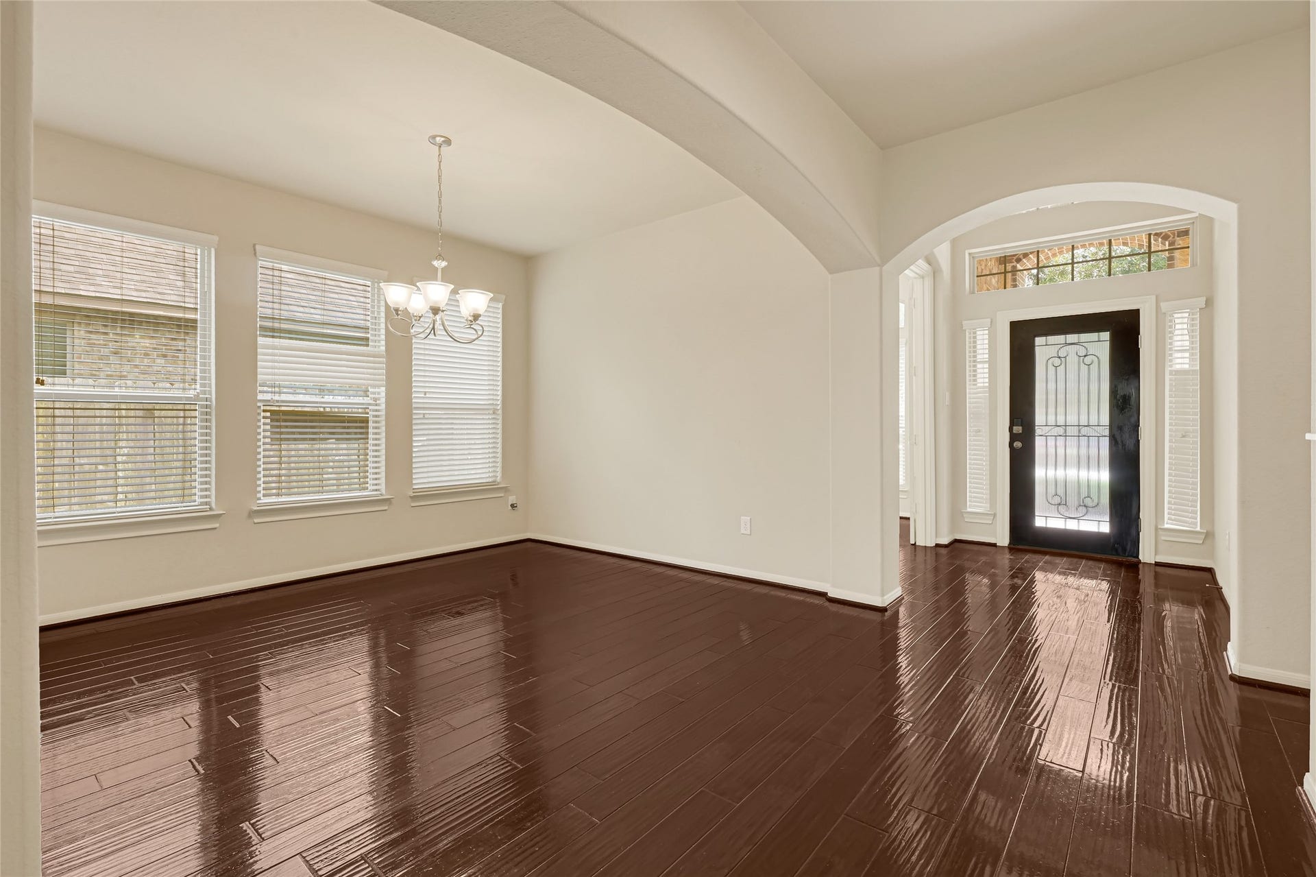 736 Somerset Landing Lane, League City, TX 77573 Formal dining room with hardwood flooring, crown molding, and an arched opening to the foyer.