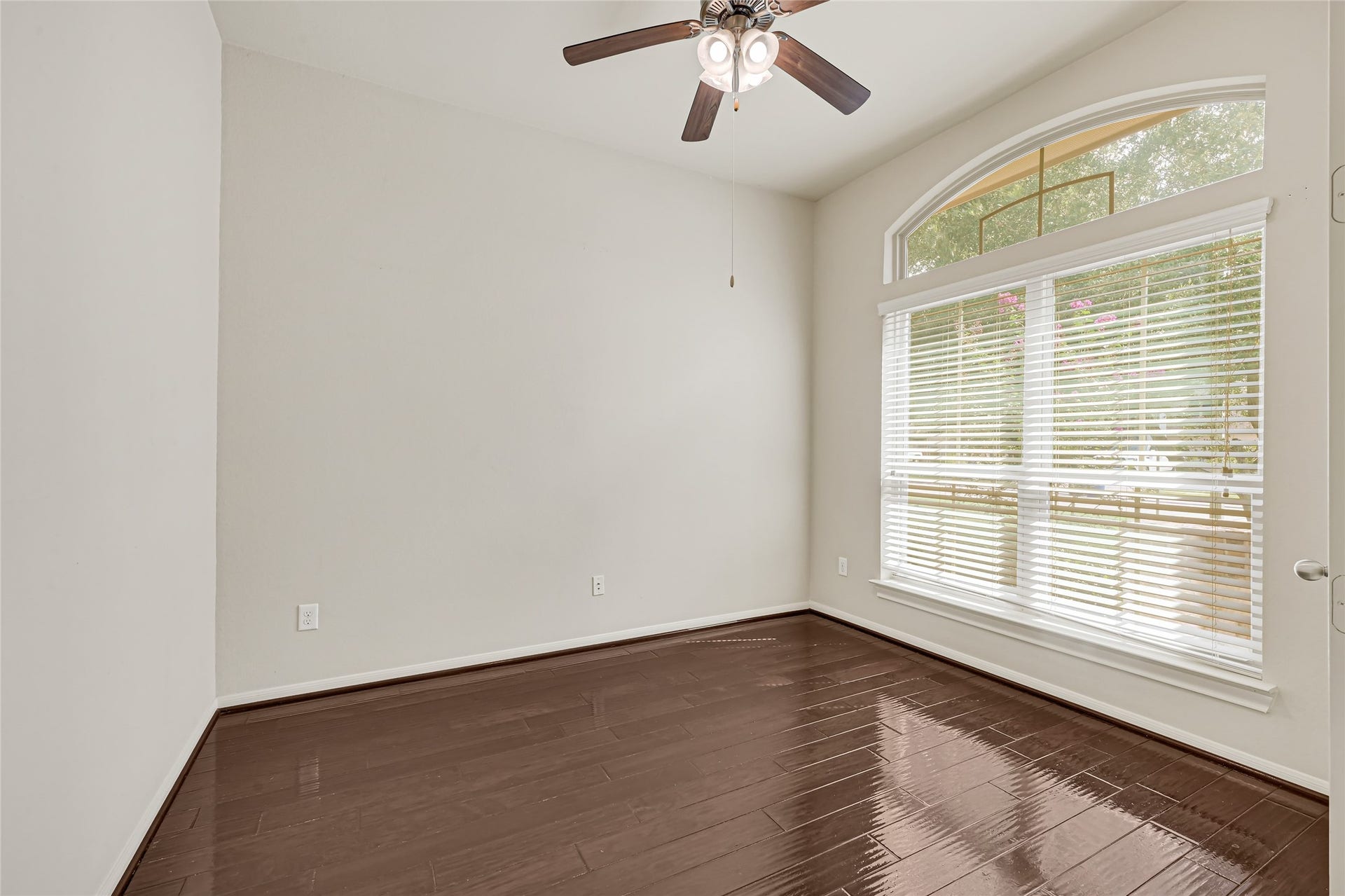 736 Somerset Landing Lane, League City, TX 77573 Versatile front room with hardwood flooring, ceiling fan, and a large window overlooking the front yard.