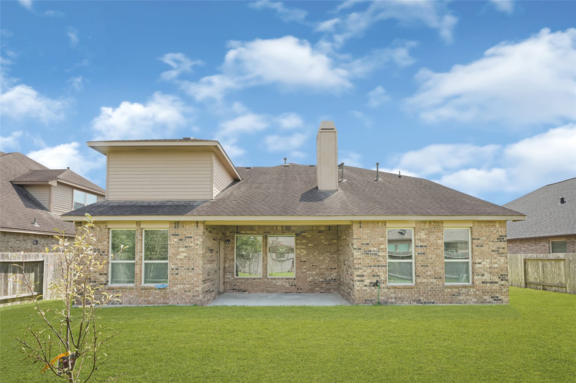 736 Somerset Landing Lane, League City, TX 77573 Spacious backyard with a full view of the homes brick exterior and multiple windows