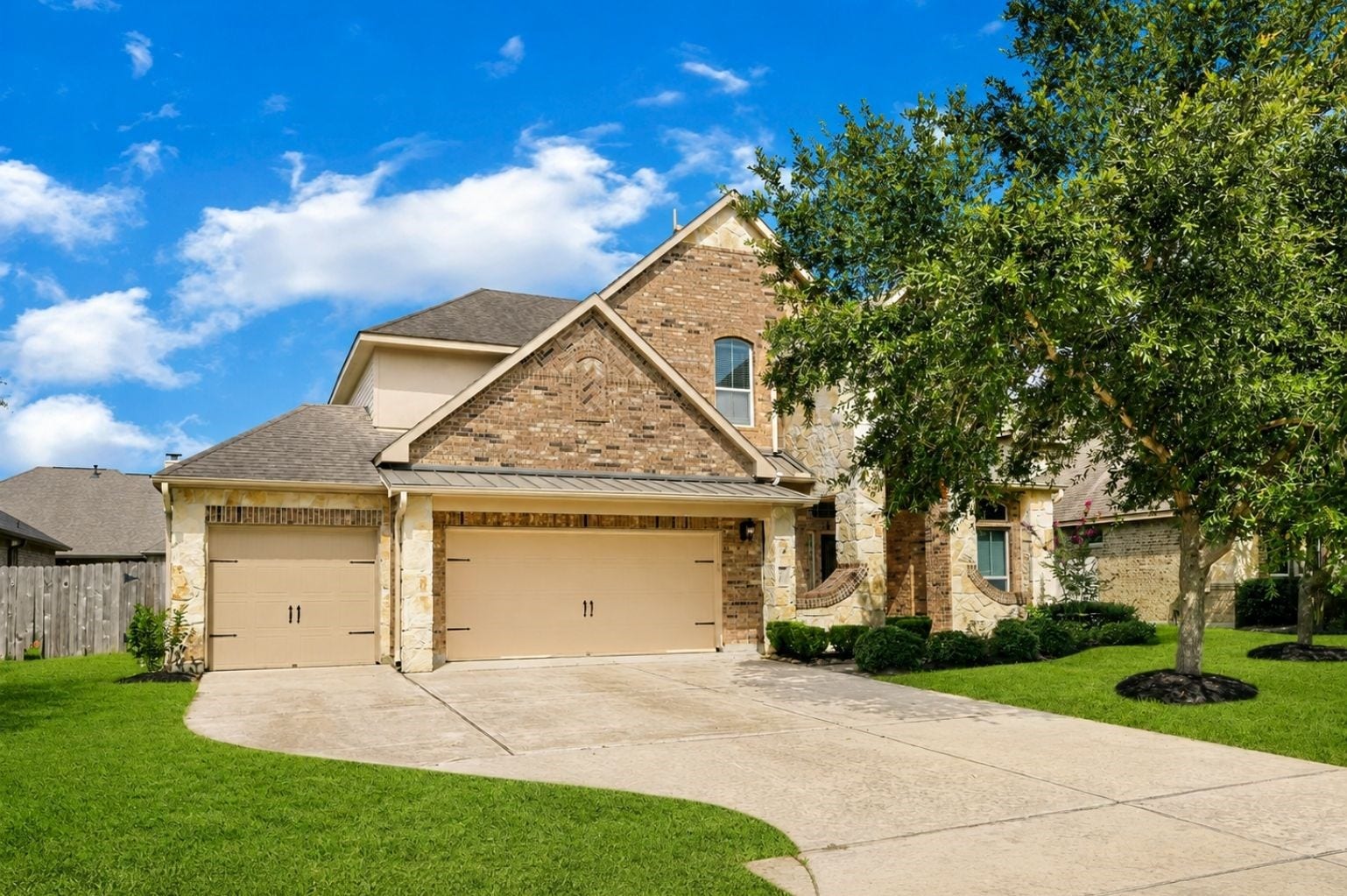 736 Somerset Landing Lane, League City, TX 77573 Attractive brick-and-stone home with a two-car garage, mature landscaping, and a spacious front lawn.