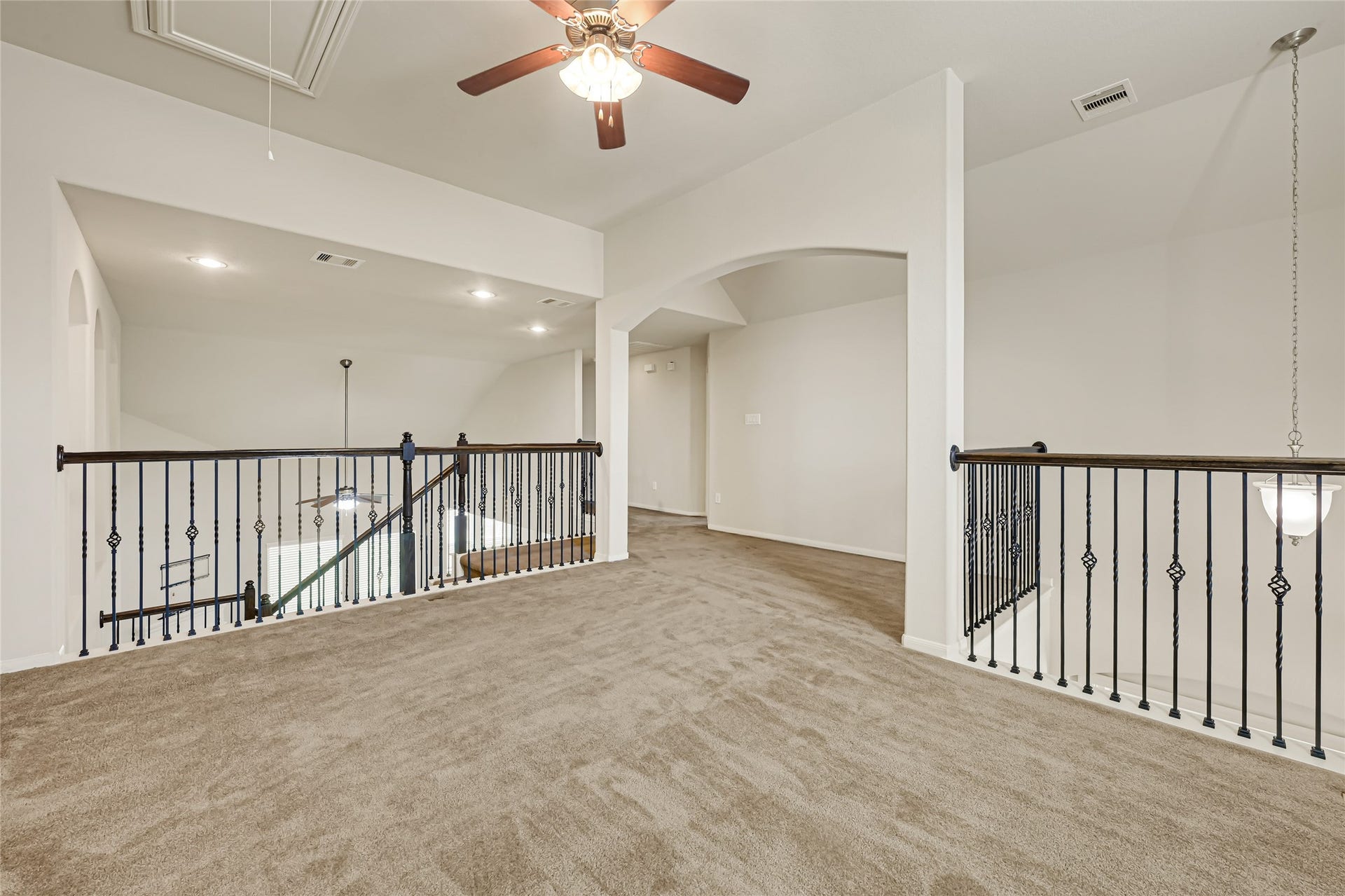 736 Somerset Landing Lane, League City, TX 77573 Spacious upstairs game room with neutral carpet, ceiling fan, and an open view to the lower level.