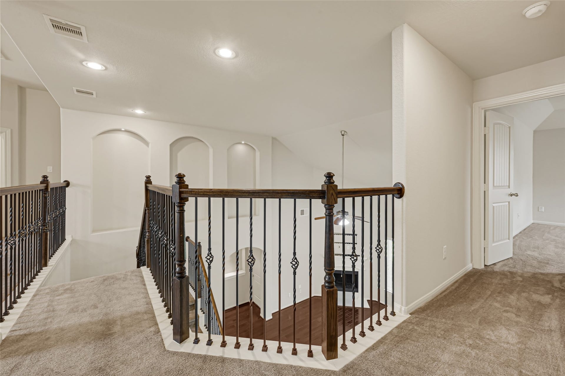 736 Somerset Landing Lane, League City, TX 77573 Open upstairs landing with wrought-iron railing, recessed lighting, and access to surrounding rooms.