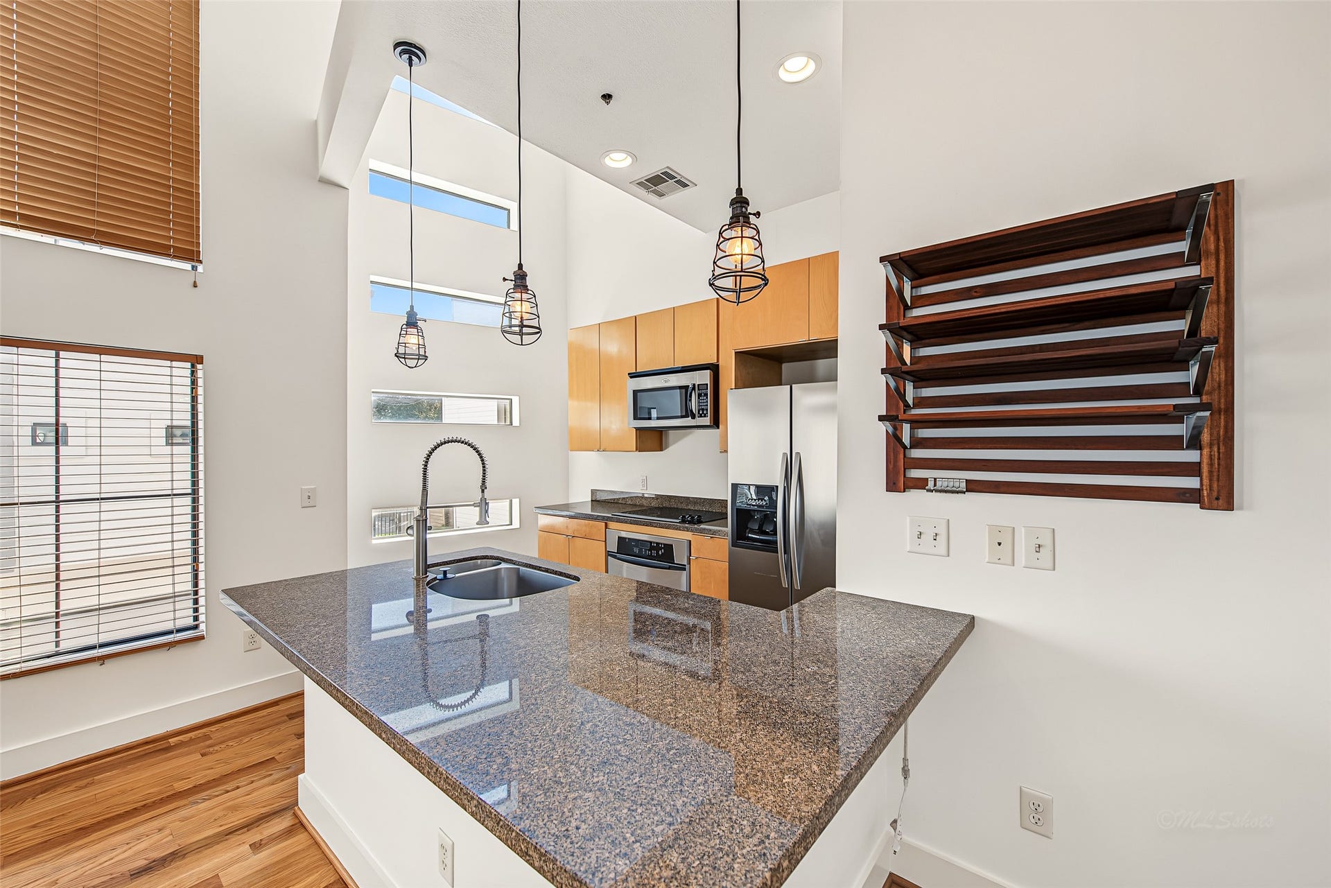 1555 Birdsall Street, #A, Houston, TX 77007 Equipped with stainless steel appliances, a gooseneck faucet, custom wine storage, and unique ribbon windows, this functional space seamlessly bridges style and everyday convenience.