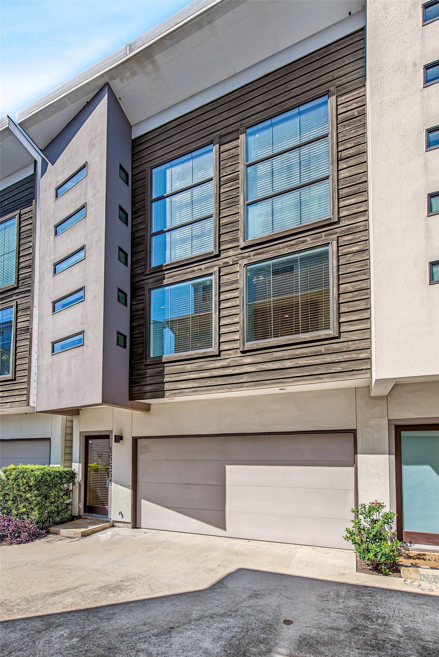 1555 Birdsall Street, #A, Houston, TX 77007 A spacious two-car garage with a streamlined overhead door ensures convenient parking and direct interior access. Neat, low-maintenance landscaping and paved surroundings frame the entryway.