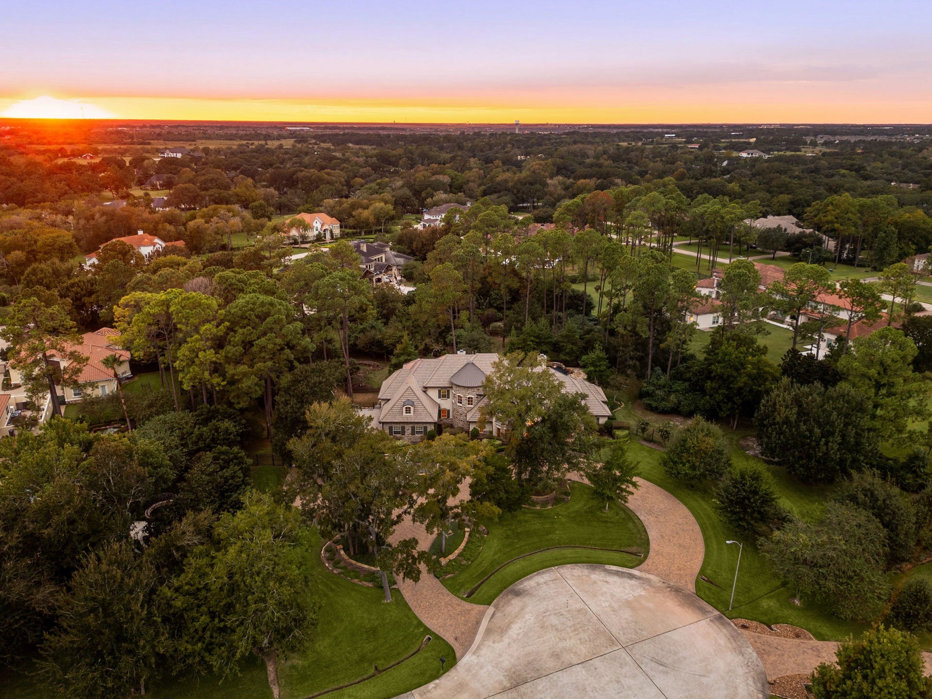 2127 Fawn Meadow Lane, Richmond, TX 77406 Aerial view showcasing the expansive grounds and surrounding natural landscape at sunset.